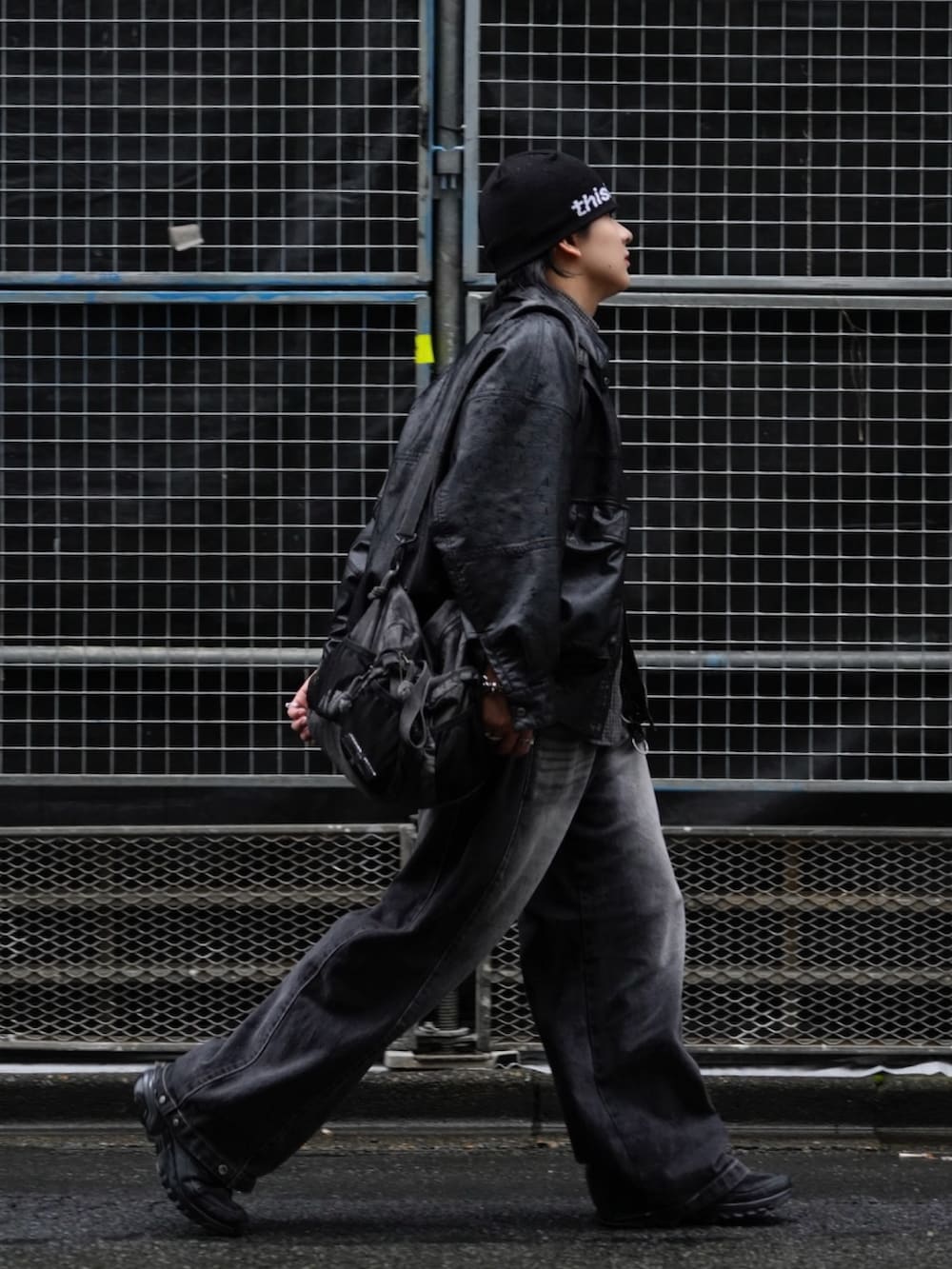 ブラック系のブルゾン、グレー系のショルダーバッグ、ブラック系のデニムパンツを着用したメンズの秋コーディネートの2枚目の写真