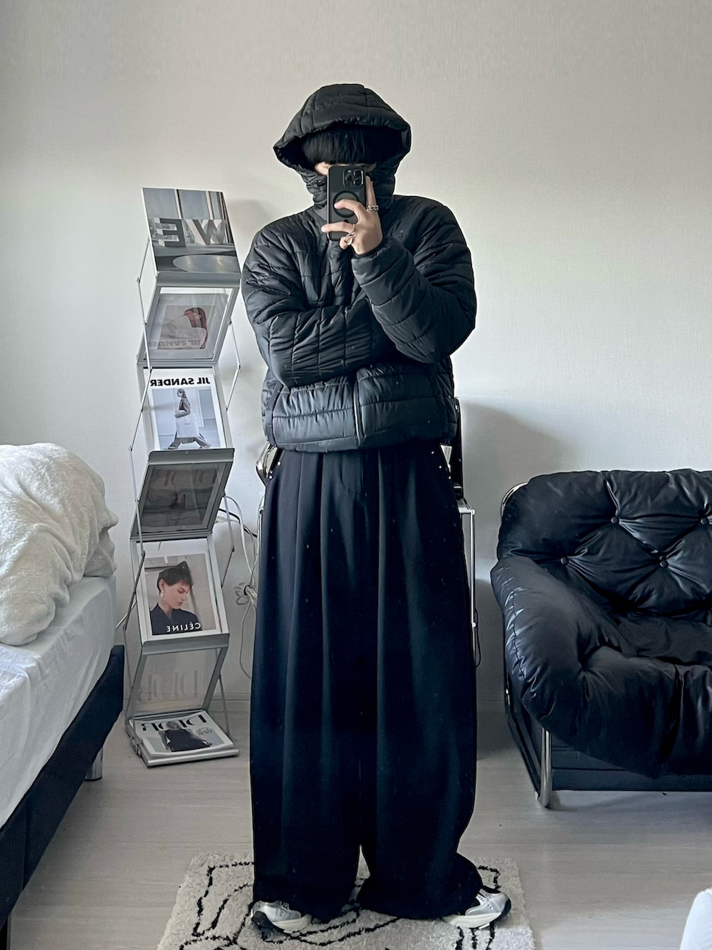 ブラック系のダウンジャケット/コート、ブラック系のTシャツ/カットソー、ブラック系のスラックスを着用したメンズの冬コーディネートの2枚目の写真