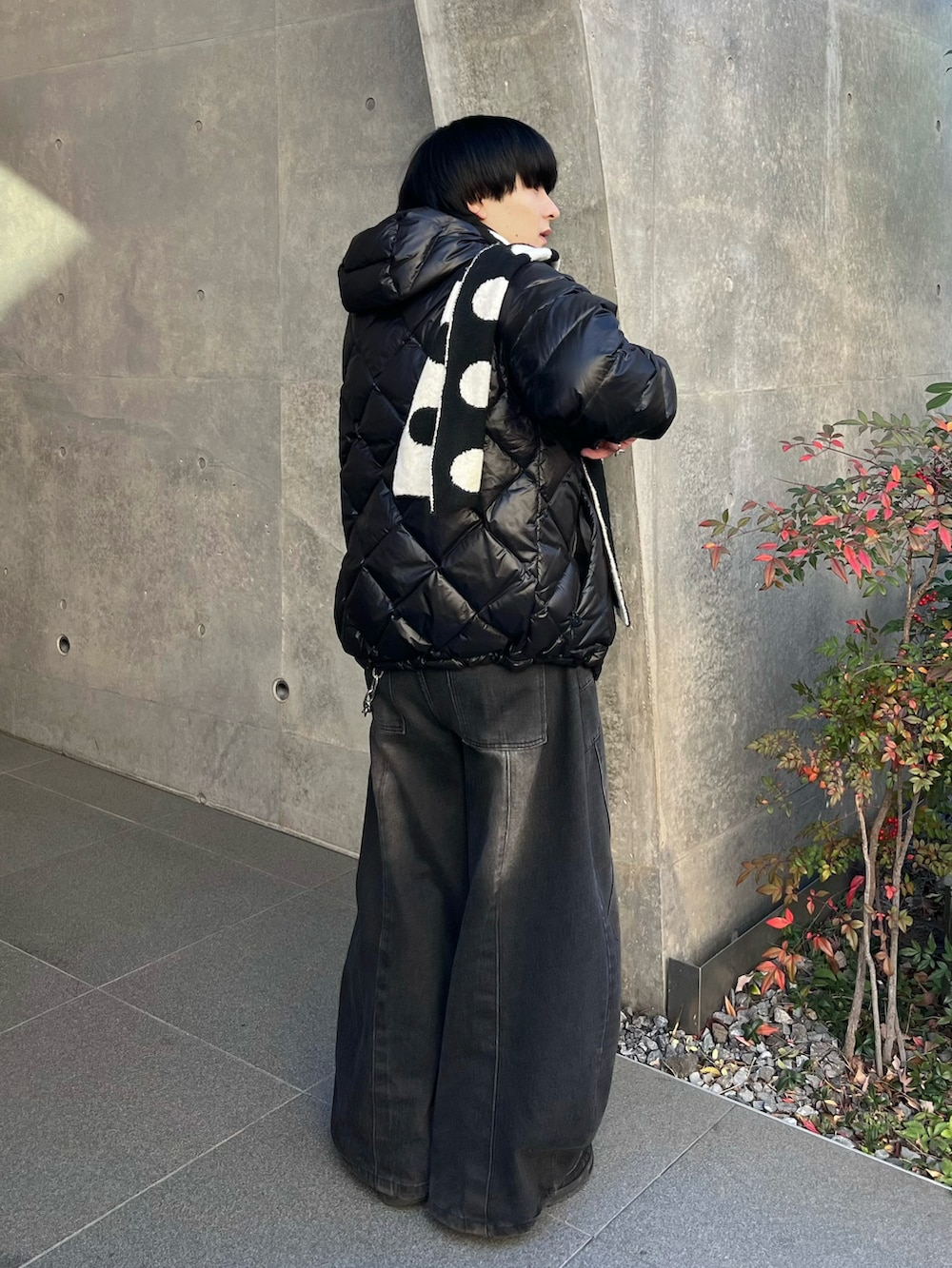 グレー系のニット/セーター、ブラック系のダウンジャケット/コート、ブラック系のデニムパンツを着用したメンズの冬コーディネートの2枚目の写真