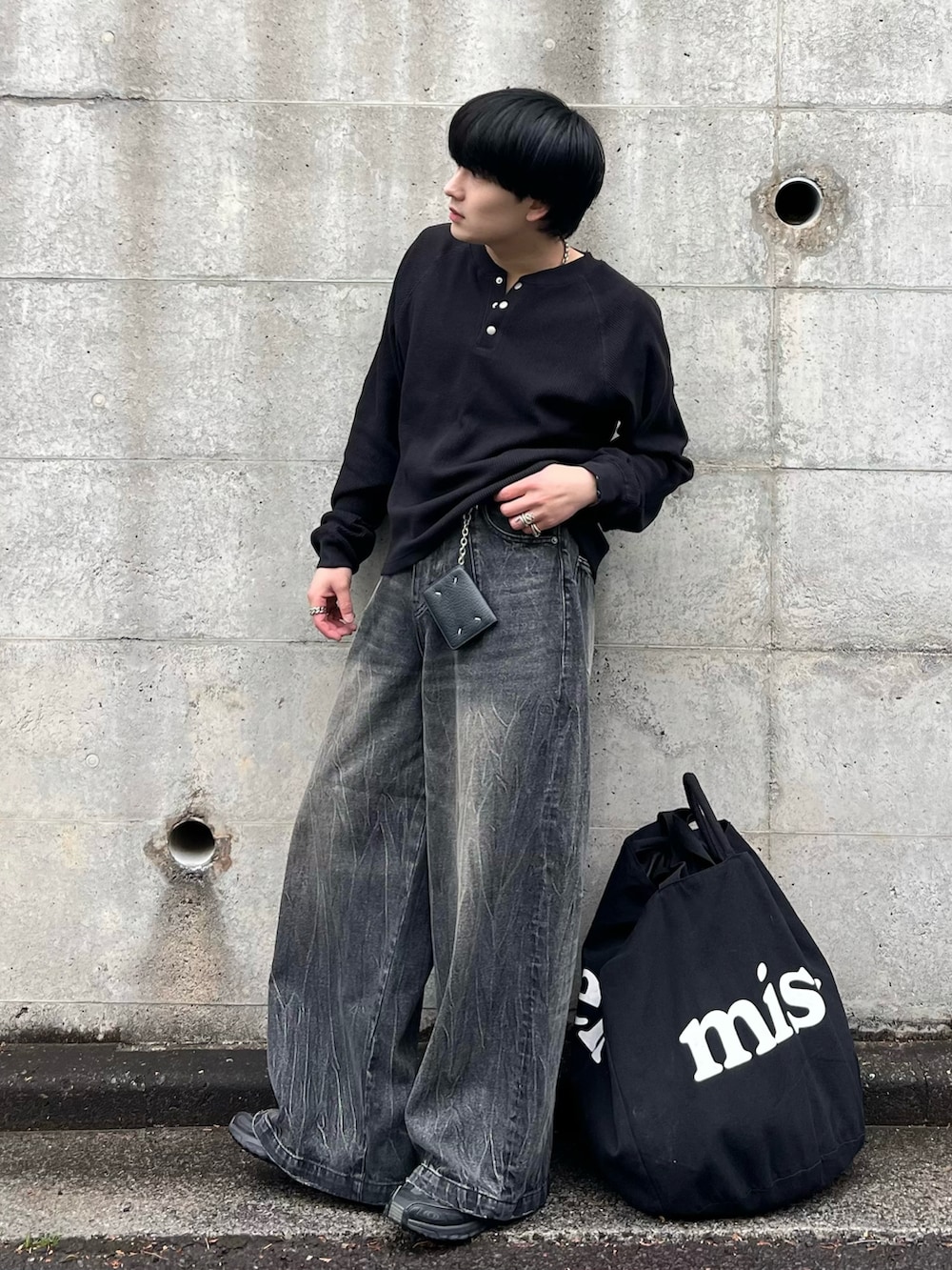 ブラック系のデニムパンツ、ブラック系のTシャツ/カットソー、ブラック系のスニーカーを着用したメンズの春コーディネートの3枚目の写真