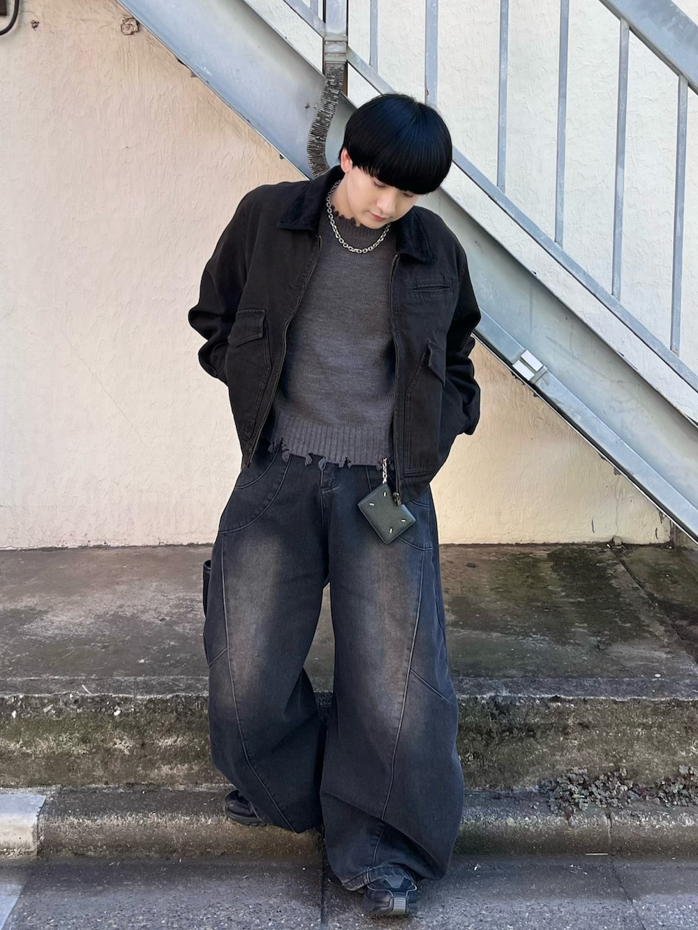 グレー系のニット/セーター、ブラック系のデニムジャケット、ブラック系のデニムパンツを着用したメンズの秋コーディネートの2枚目の写真