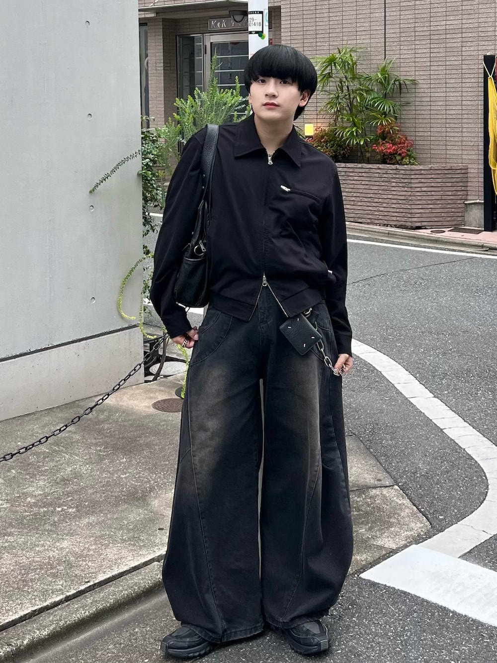 ブラック系のブルゾン、ブラック系のデニムパンツ、ブラック系のスニーカーを着用したメンズの秋コーディネートの2枚目の写真