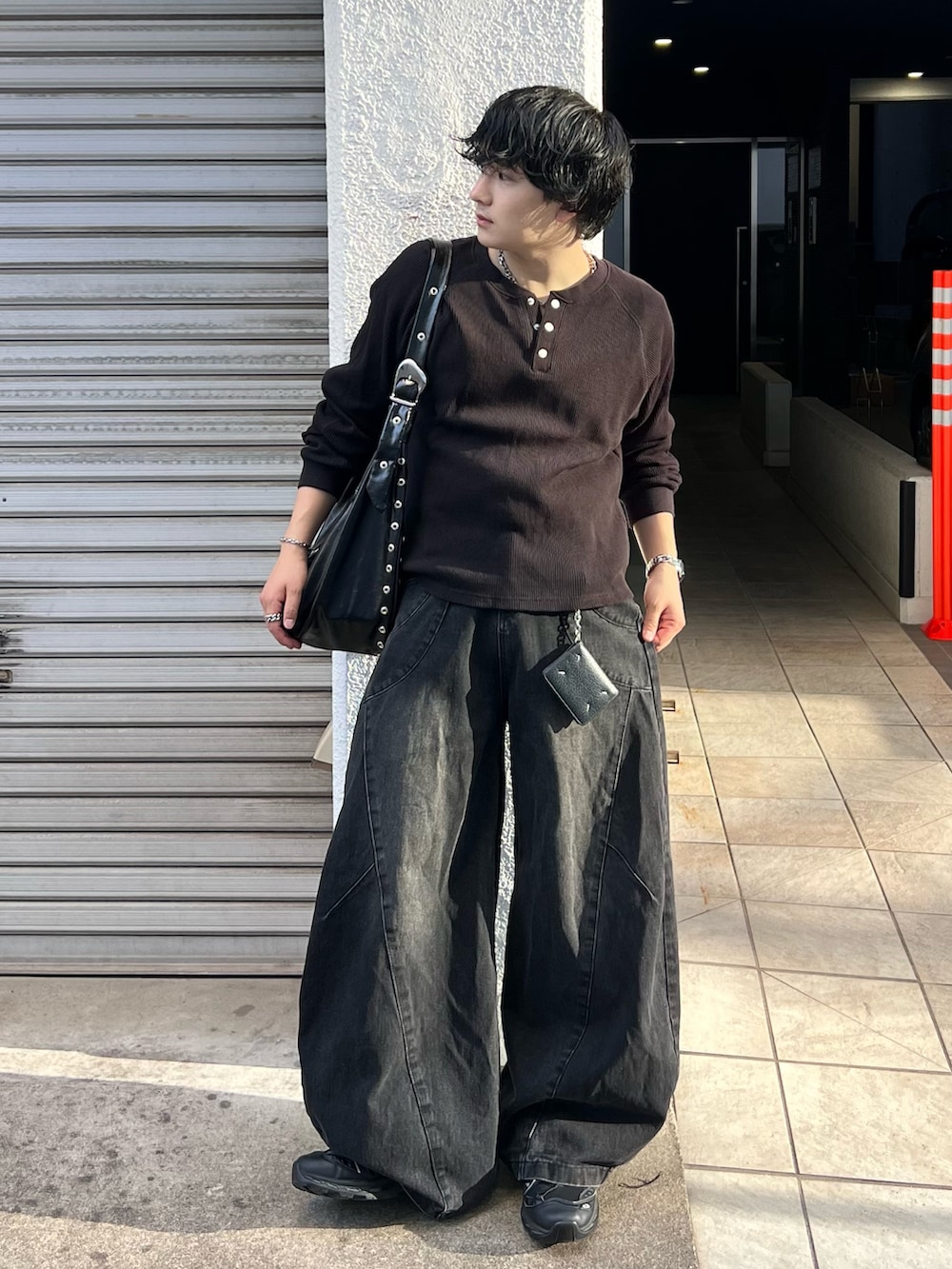 ブラック系のTシャツ/カットソー、ブラック系のデニムパンツ、ブラック系のショルダーバッグを着用したメンズの秋コーディネートの2枚目の写真