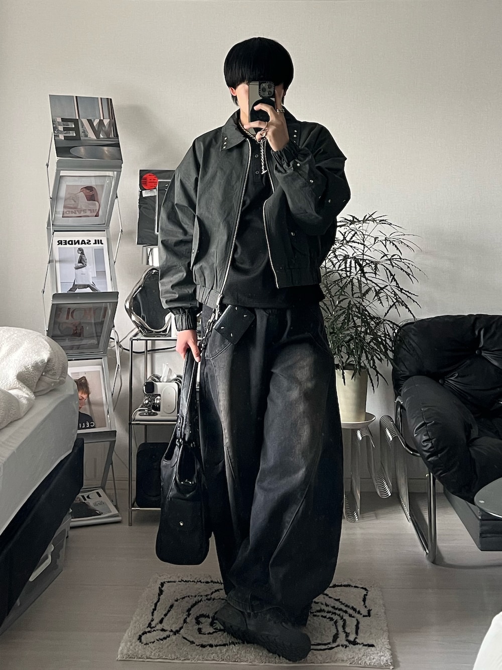 ブラック系のブルゾン、ブラック系のTシャツ/カットソー、ブラック系のデニムパンツを着用したメンズの冬コーディネートの2枚目の写真