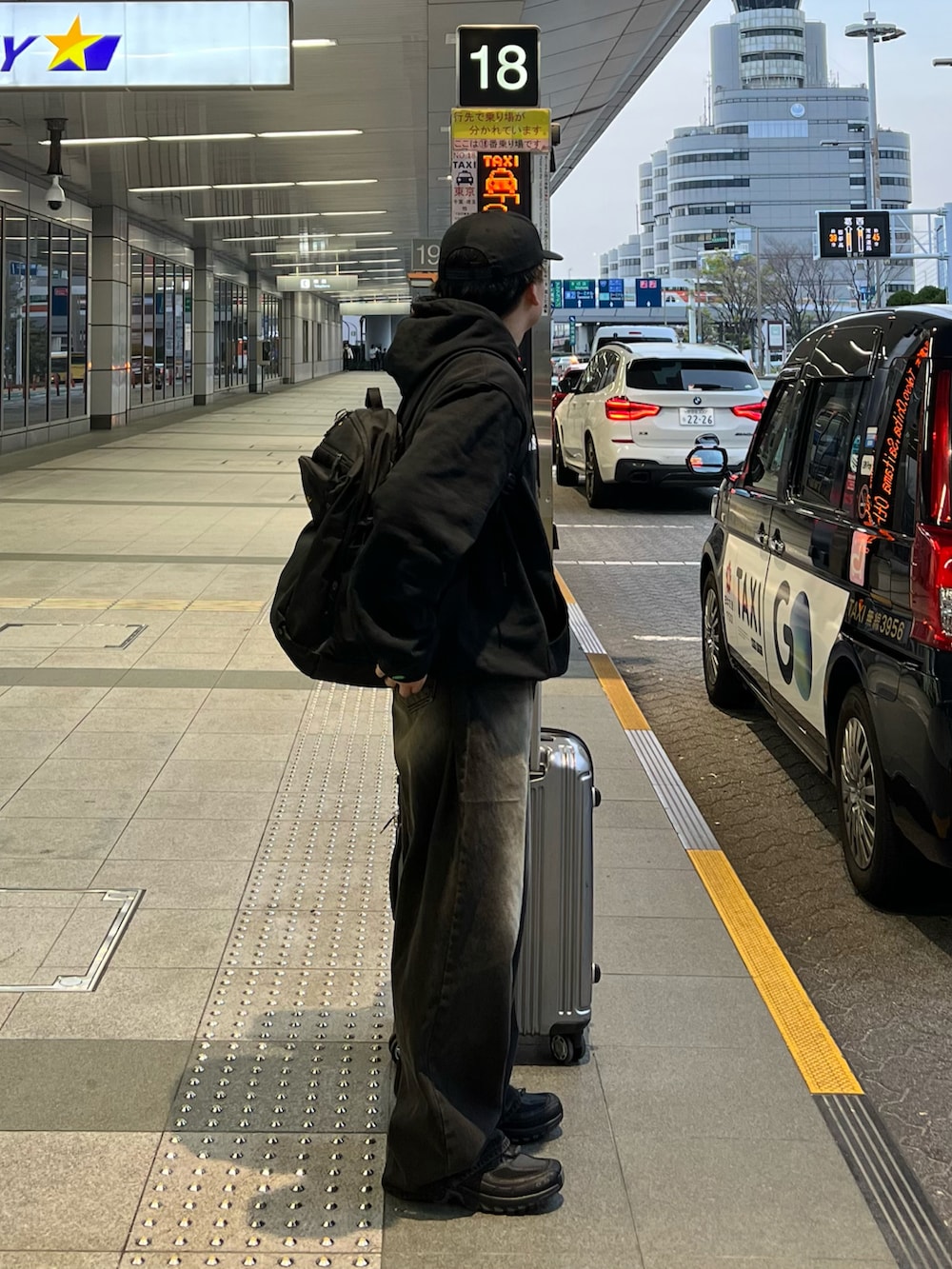 ブラック系のバックパック/リュック、ブラック系のデニムパンツ、ブラック系のスニーカーを着用したメンズの夏コーディネートの2枚目の写真