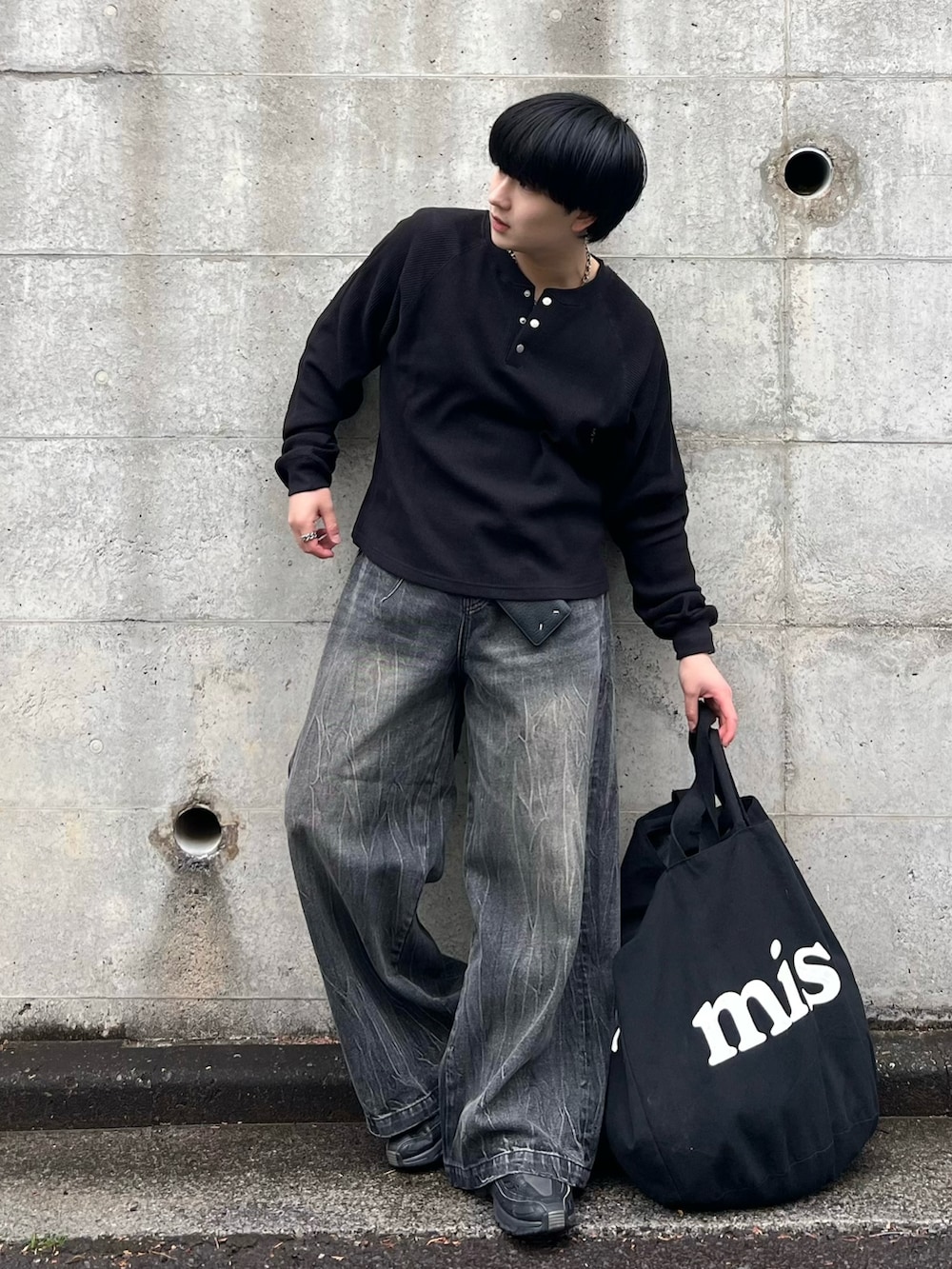 ブラック系のデニムパンツ、ブラック系のTシャツ/カットソー、ブラック系のスニーカーを着用したメンズの春コーディネートの2枚目の写真