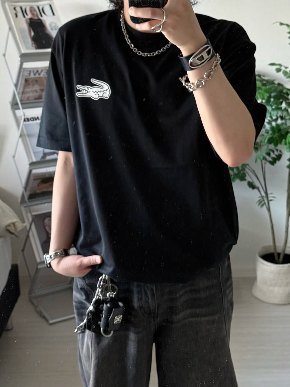 ブラック系のデニムパンツ、ブラック系のTシャツ/カットソー、ブラック系のスニーカーを着用したメンズの春コーディネートの3枚目の写真