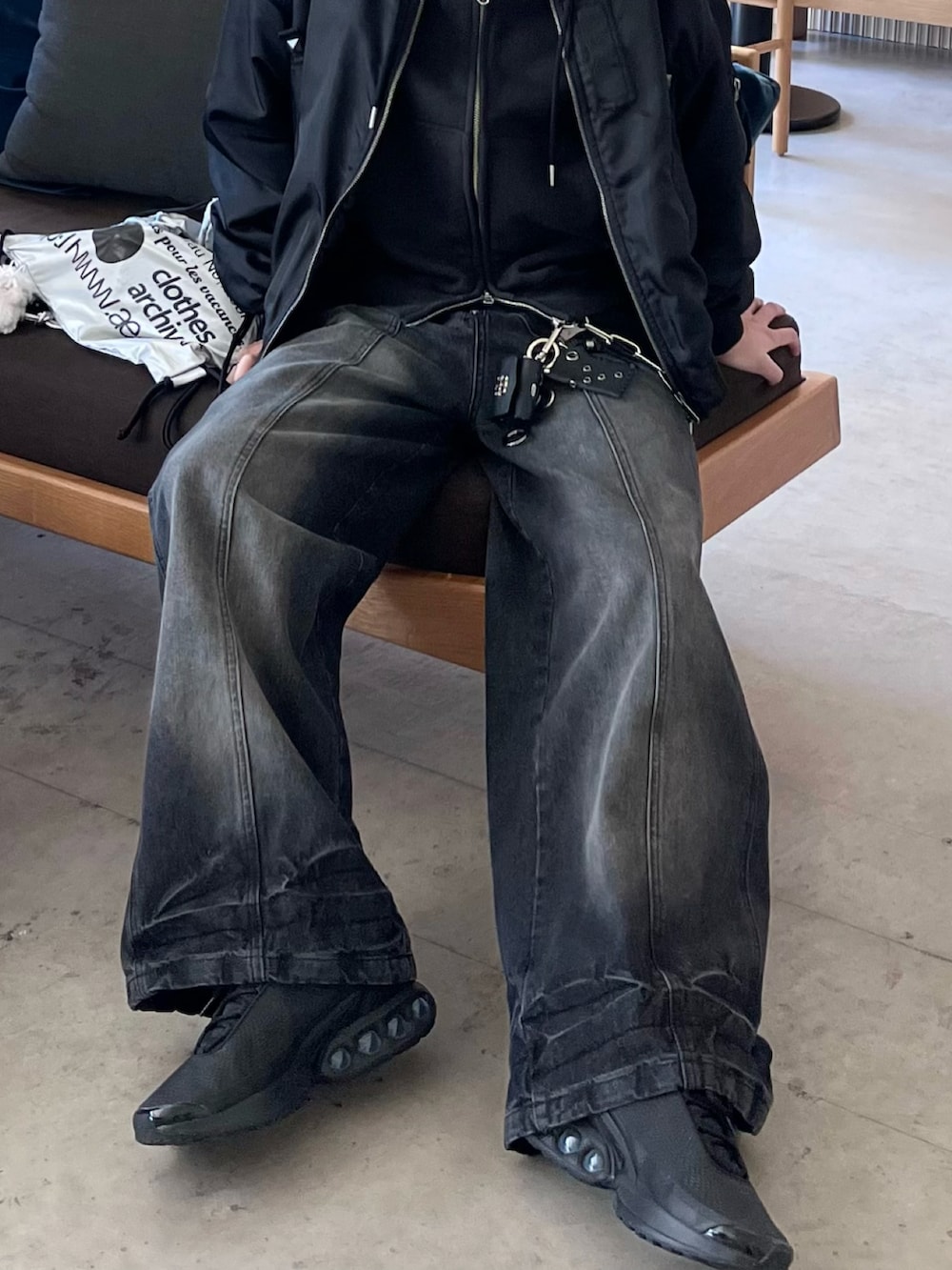 ブラック系のスニーカー、ブラック系のデニムパンツ、ブラック系のパーカーを着用したメンズの春コーディネートの3枚目の写真