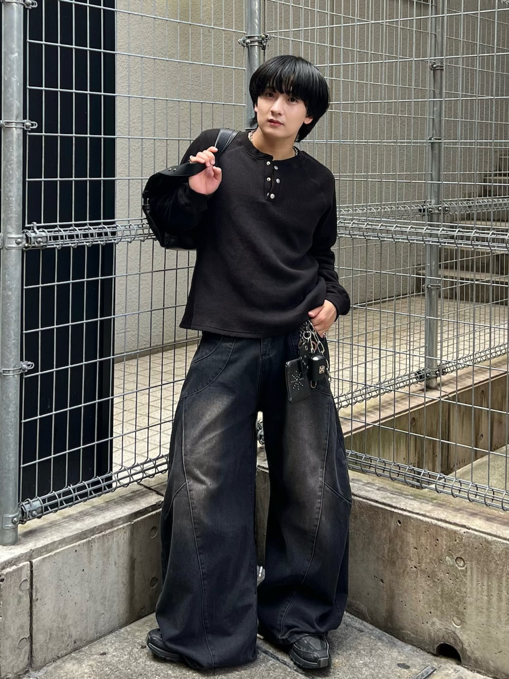 ブラック系のTシャツ/カットソー、ブラック系のデニムパンツ、ブラック系のショルダーバッグを着用したメンズの秋コーディネートの2枚目の写真