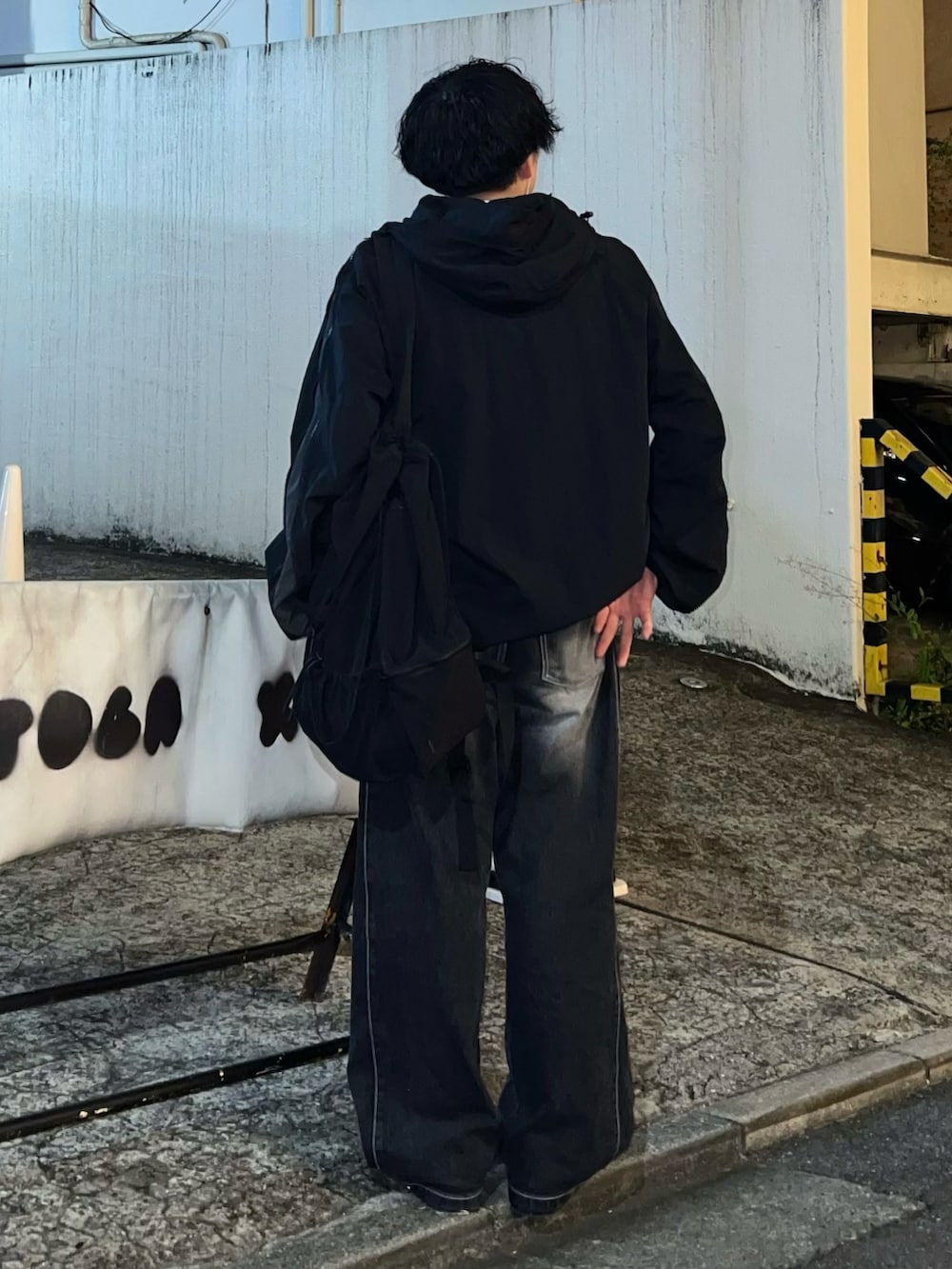 ブラック系のデニムパンツ、ブラック系のスニーカー、ホワイト系のTシャツ/カットソーを着用したメンズの秋コーディネートの3枚目の写真