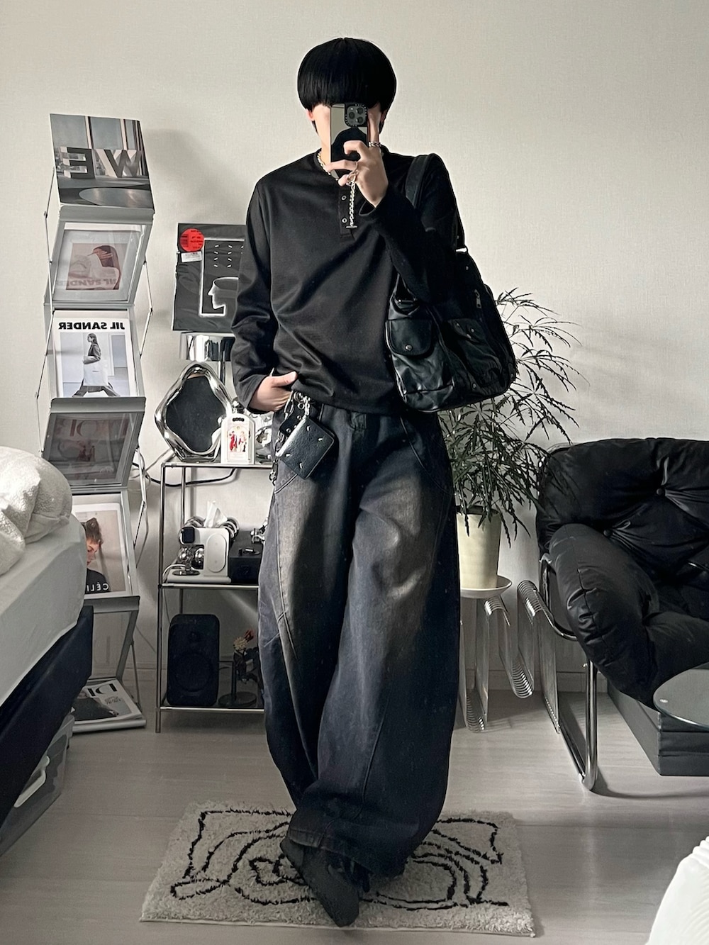 ブラック系のスニーカー、ブラック系のTシャツ/カットソー、ブラック系のデニムパンツを着用したメンズの冬コーディネートの2枚目の写真