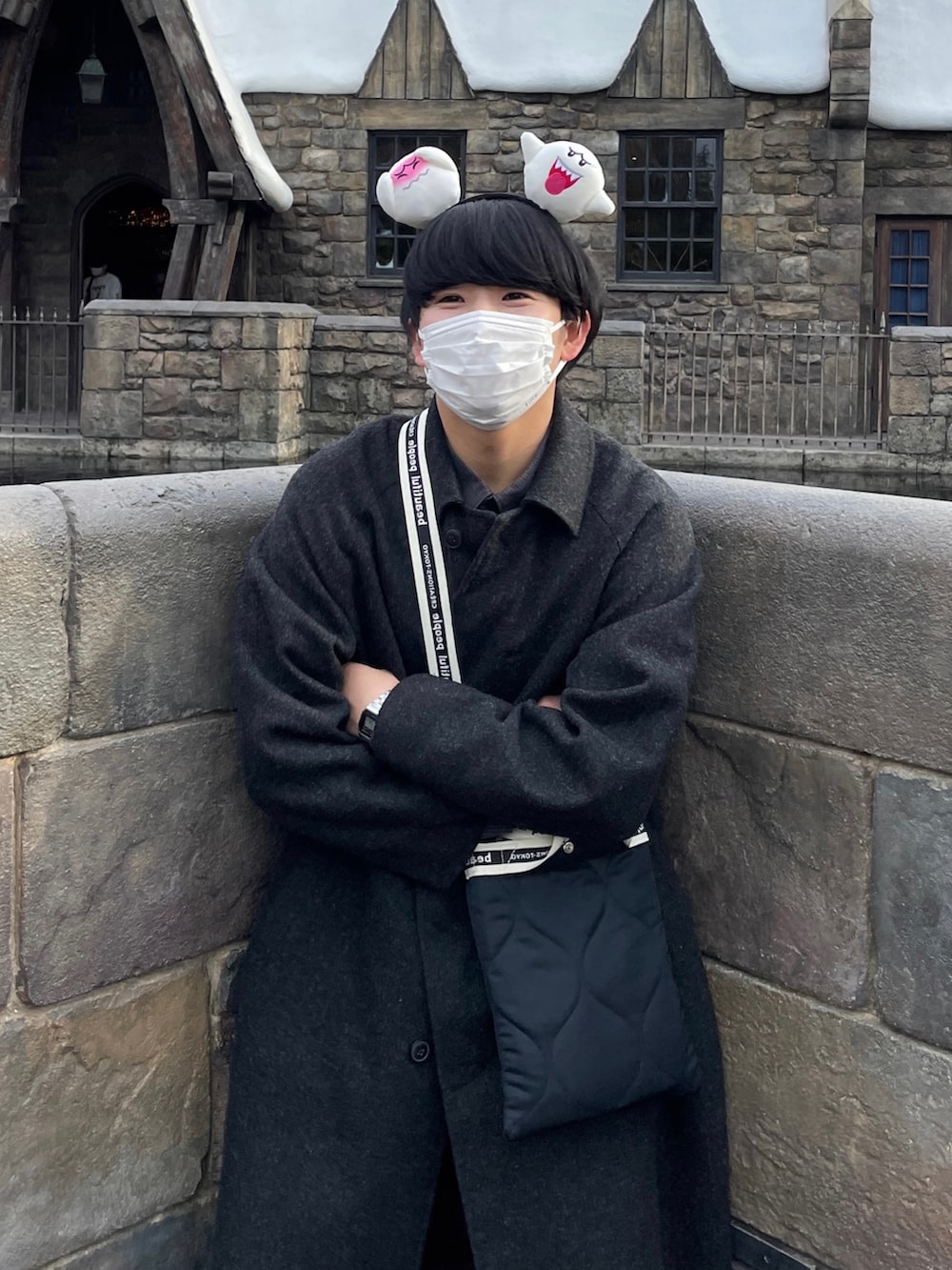 ブラック系のショルダーバッグ、ブラック系のステンカラーコート、ブラック系のスラックスを着用したメンズの秋コーディネートの2枚目の写真