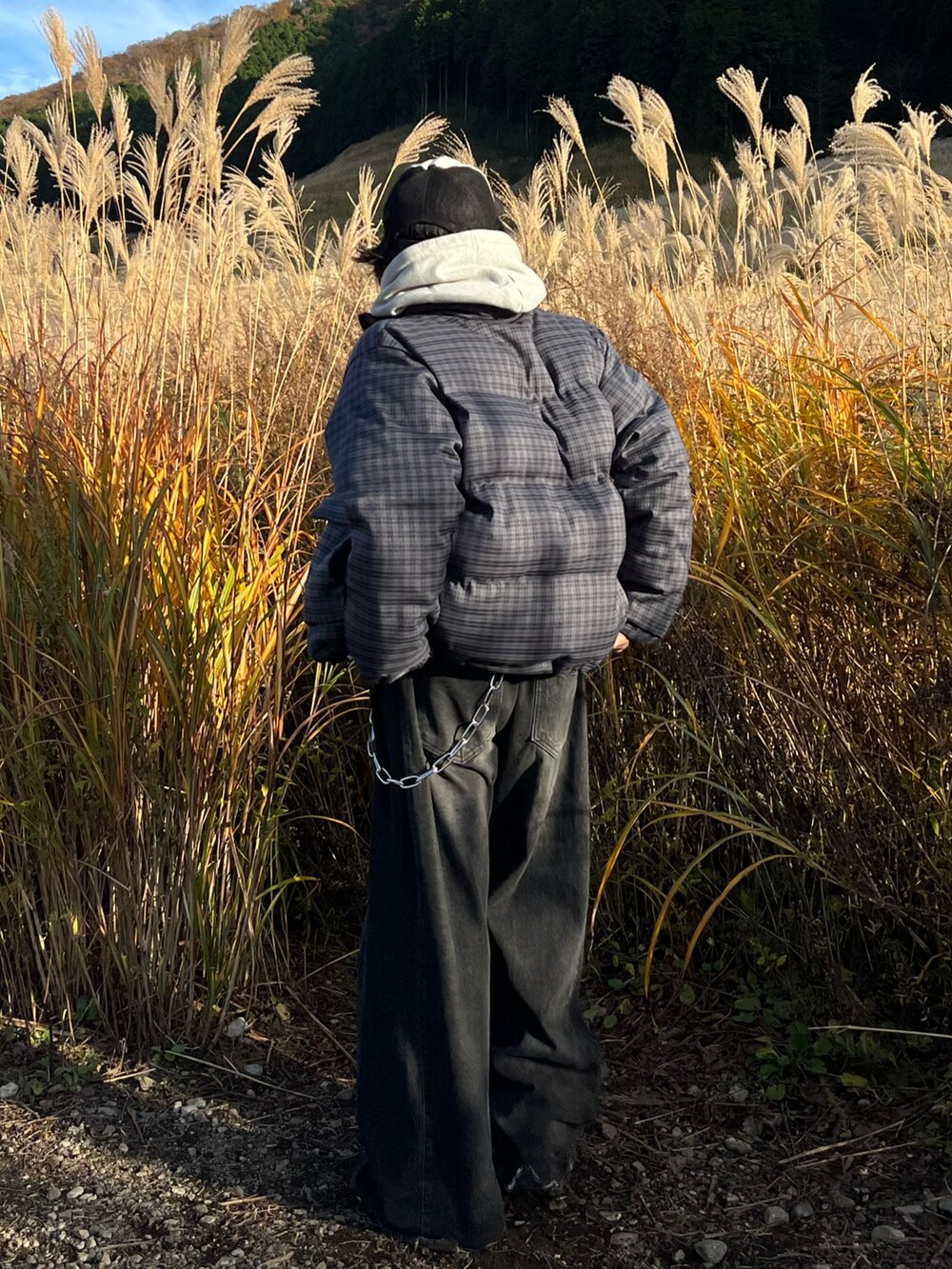 グレー系のパーカー、ブルー系のブルゾン、ブラック系のデニムパンツを着用したメンズの秋コーディネートの3枚目の写真