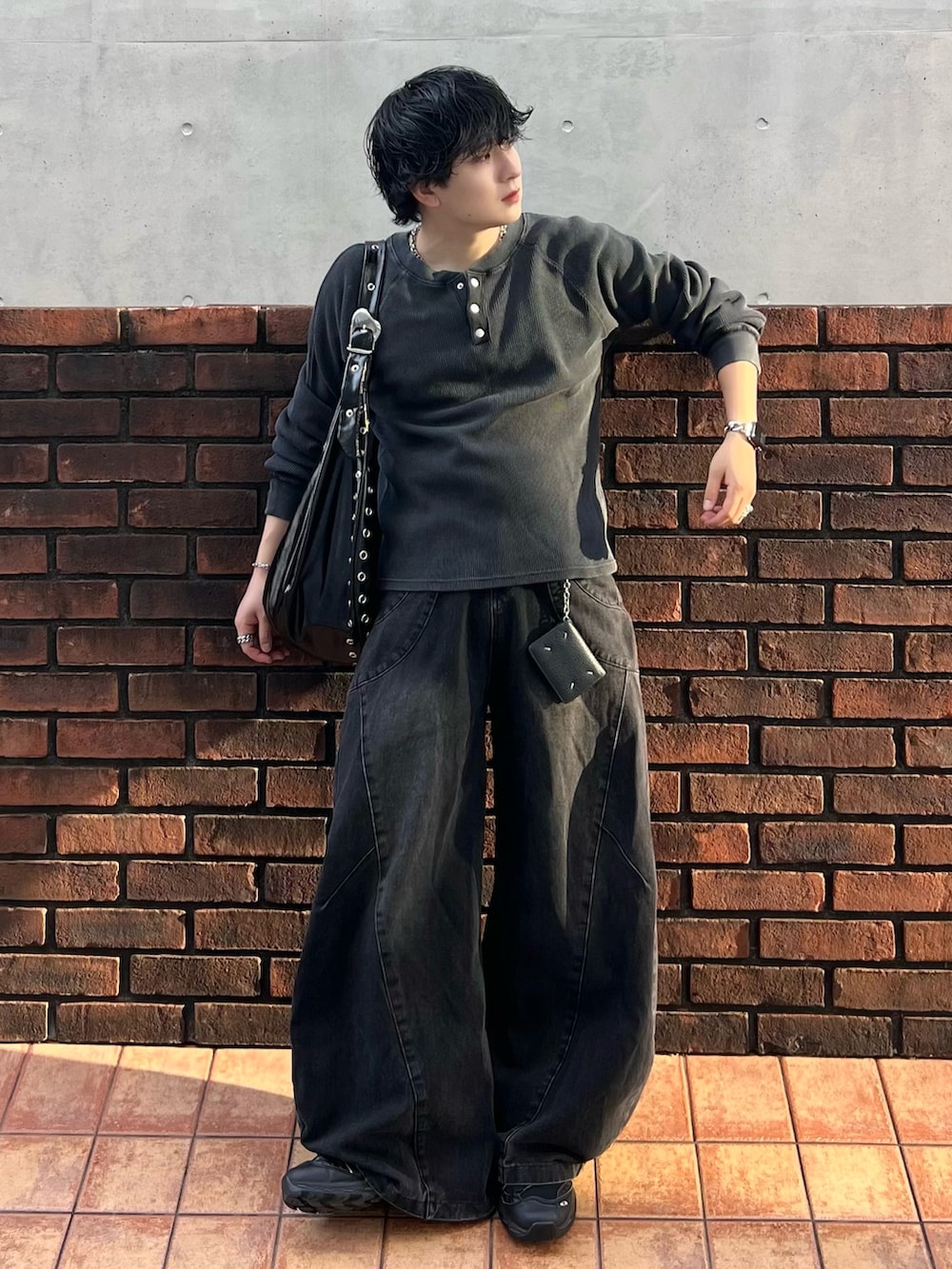 ブラック系のデニムパンツ、グレー系のTシャツ/カットソー、ブラック系のショルダーバッグを着用したメンズの秋コーディネートの2枚目の写真