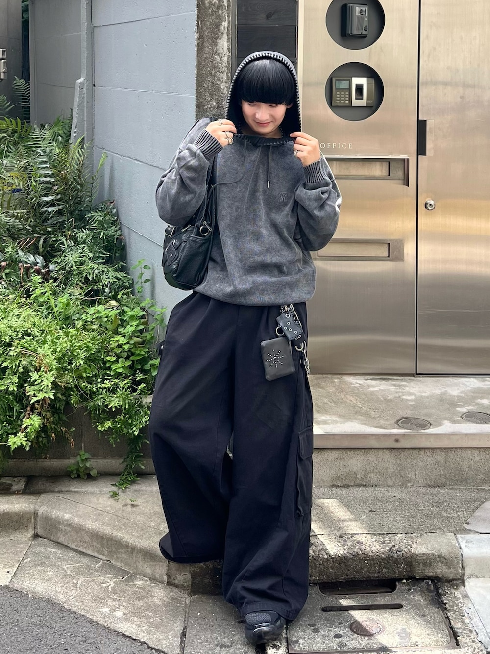 ブラック系のパーカー、ブラック系のカーゴパンツ、ブラック系のスニーカーを着用したメンズの夏コーディネートの3枚目の写真