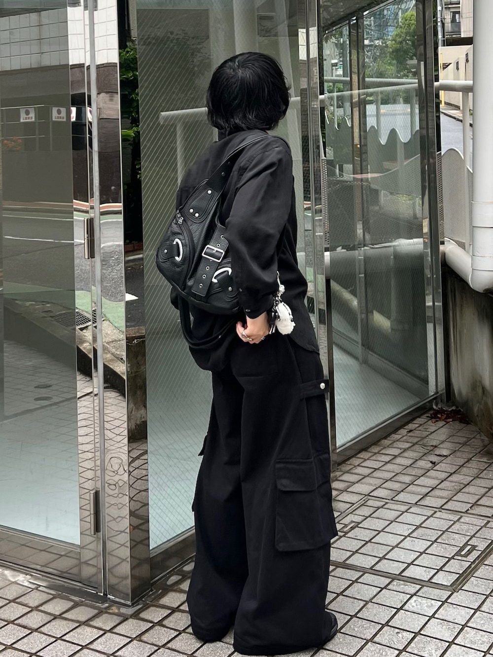 ブラック系のシャツ/ブラウス、ブラック系のカーゴパンツ、ブラック系のスニーカーを着用したメンズの春コーディネートの2枚目の写真