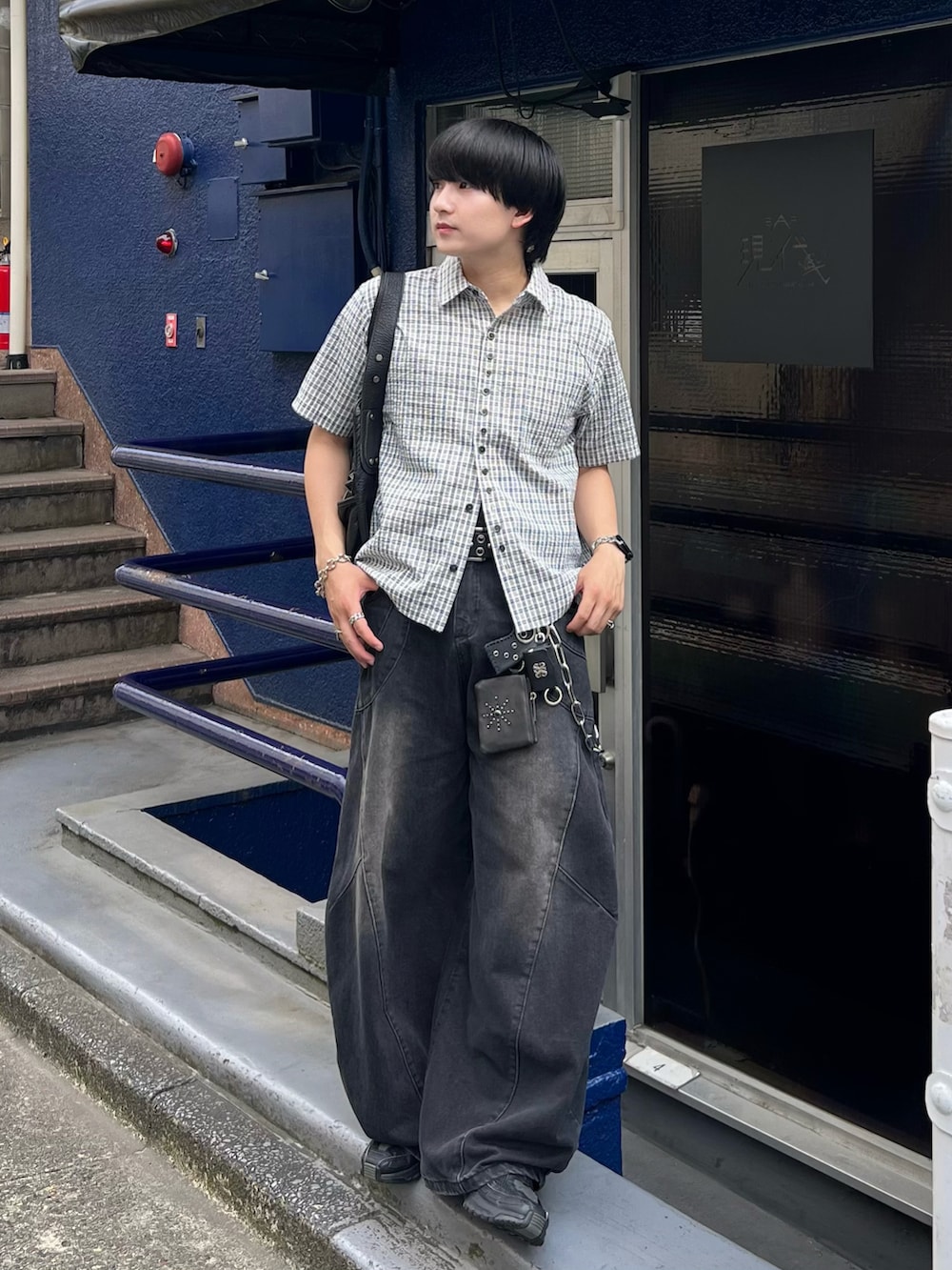 ブラック系のデニムパンツ、ブルー系のシャツ/ブラウス、ブラック系のショルダーバッグを着用したメンズの夏コーディネートの2枚目の写真