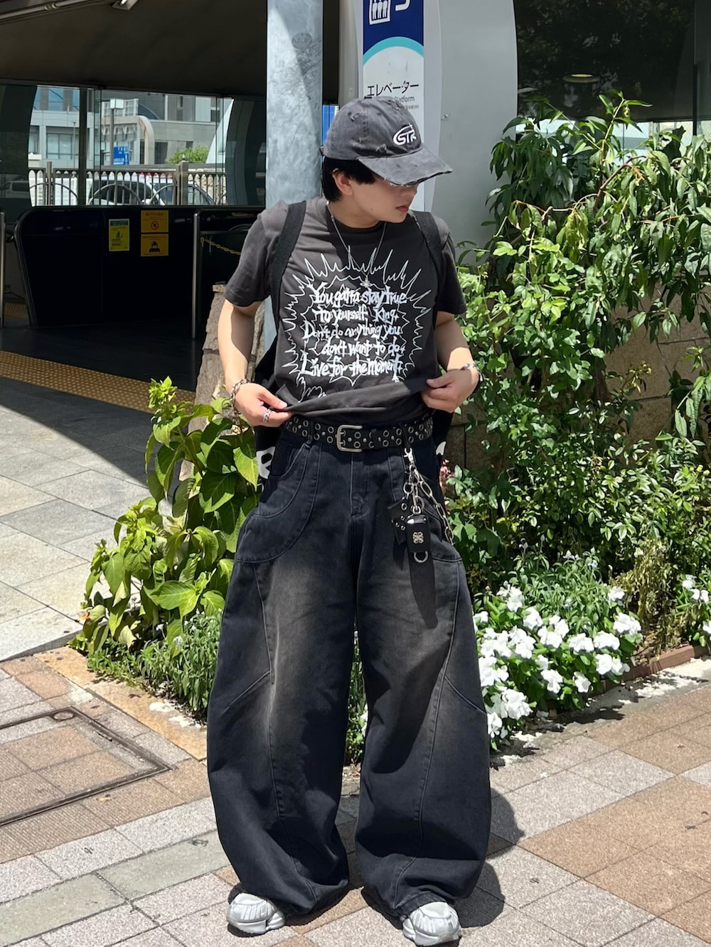 ブラック系のデニムパンツ、グレー系のTシャツ/カットソー、シルバー系のスニーカーを着用したメンズの夏コーディネートの2枚目の写真