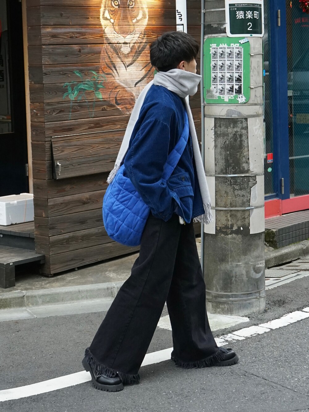 ブルー系のテーラードジャケット、ブラック系のデニムパンツ、ブルー系のショルダーバッグを着用したメンズの冬コーディネートの3枚目の写真