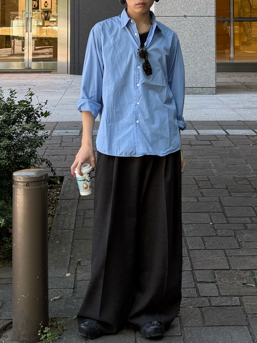 ブルー系のシャツ/ブラウス、ブラウン系のスラックス、ブルー系のタンクトップを着用したメンズの春コーディネートの3枚目の写真