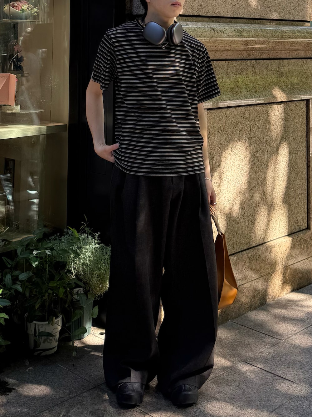 ブラック系のTシャツ/カットソー、ブラック系のスニーカー、ブラウン系のスラックスを着用したメンズの夏コーディネートの5枚目の写真