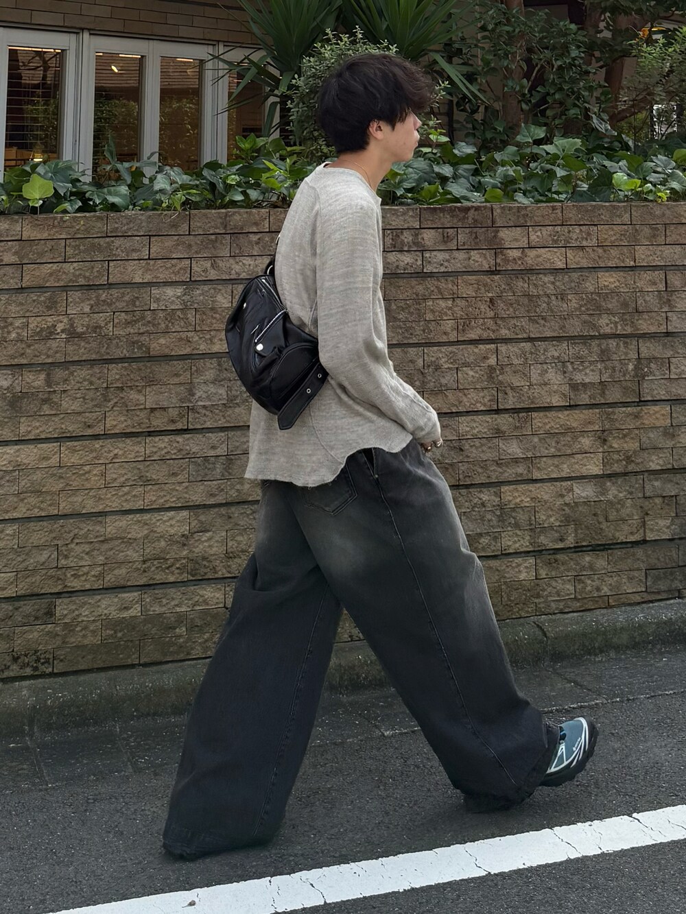 グレー系のTシャツ/カットソー、ブラック系のデニムパンツ、ブラック系のショルダーバッグを着用したメンズの秋コーディネートの3枚目の写真
