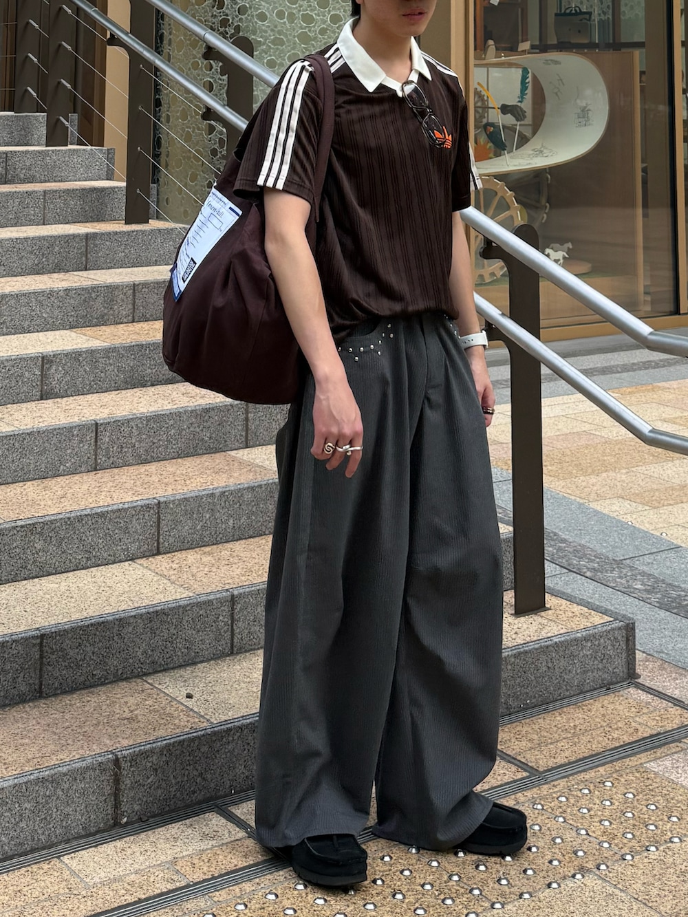 ブラウン系のTシャツ/カットソー、グレー系のスラックス、ブラウン系のトートバッグを着用したメンズの夏コーディネートの5枚目の写真