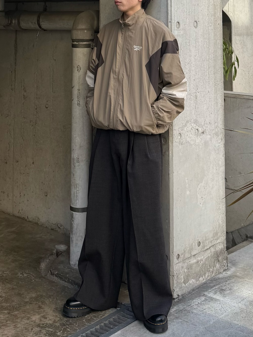 ベージュ系のナイロンジャケットを着用したメンズの春コーディネートの3枚目の写真