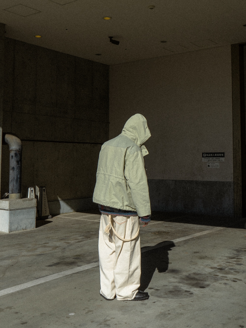 ベージュ系のマウンテンパーカー、ブラック系のデニムパンツ、ブラック系のブーツを着用したメンズの冬コーディネートの3枚目の写真