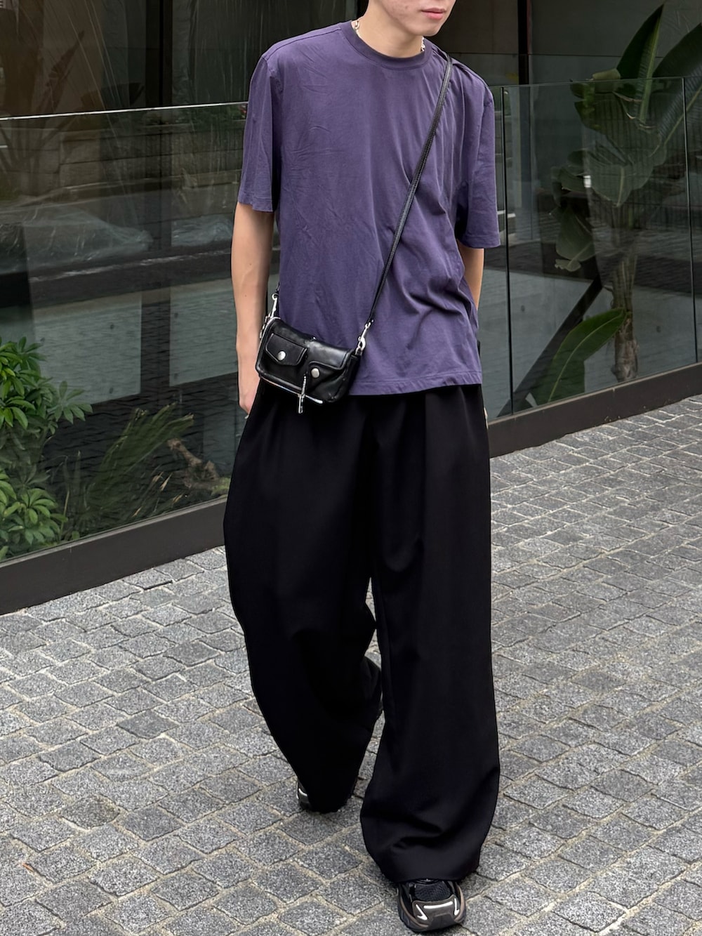 ブルー系のTシャツ/カットソー、ブラック系のスラックス、ブラウン系のスニーカーを着用したメンズの夏コーディネートの3枚目の写真