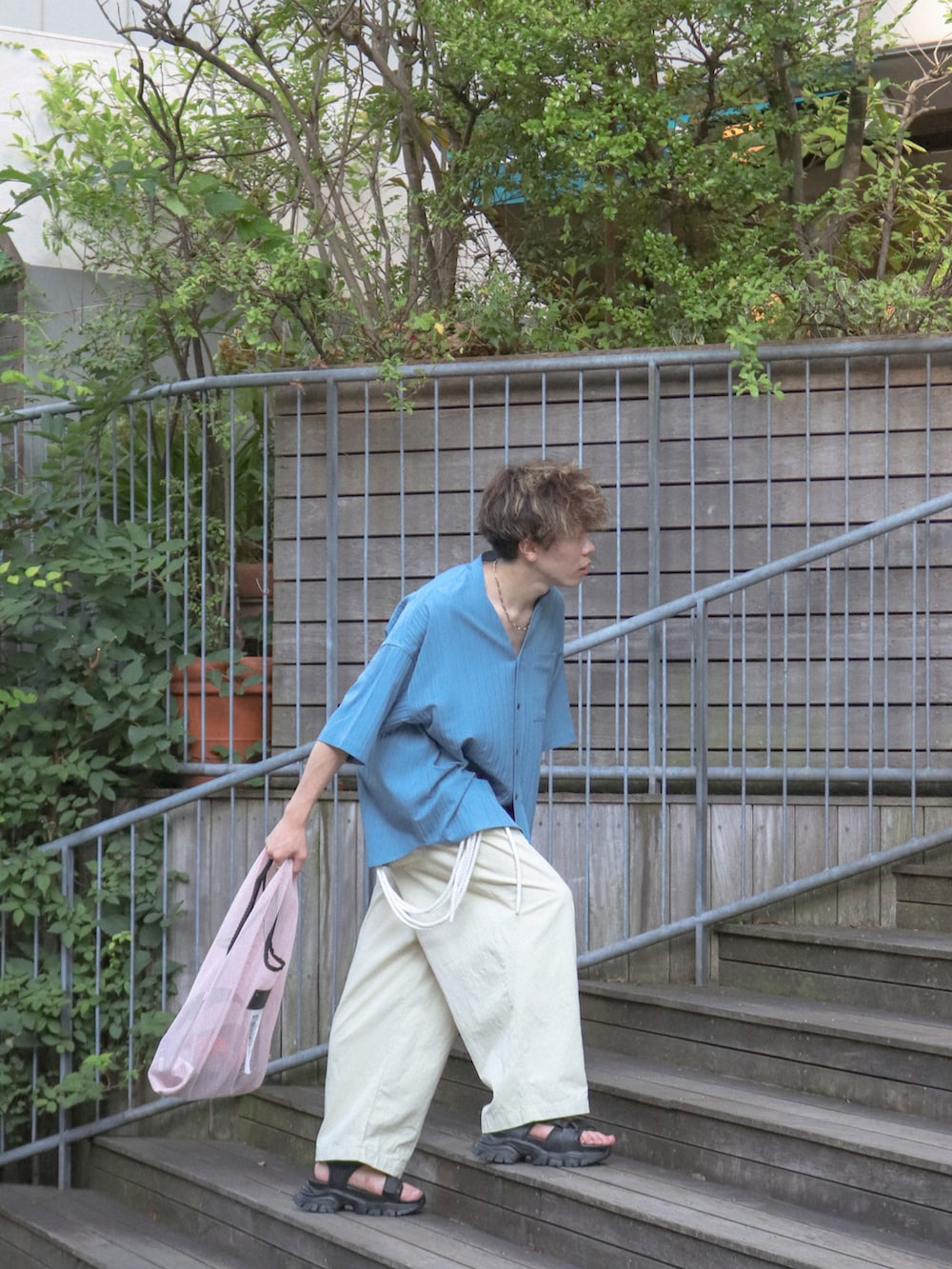 ピンク系のトートバッグ、ブラック系のサンダル、ブルー系のその他を着用したメンズの夏コーディネートの3枚目の写真