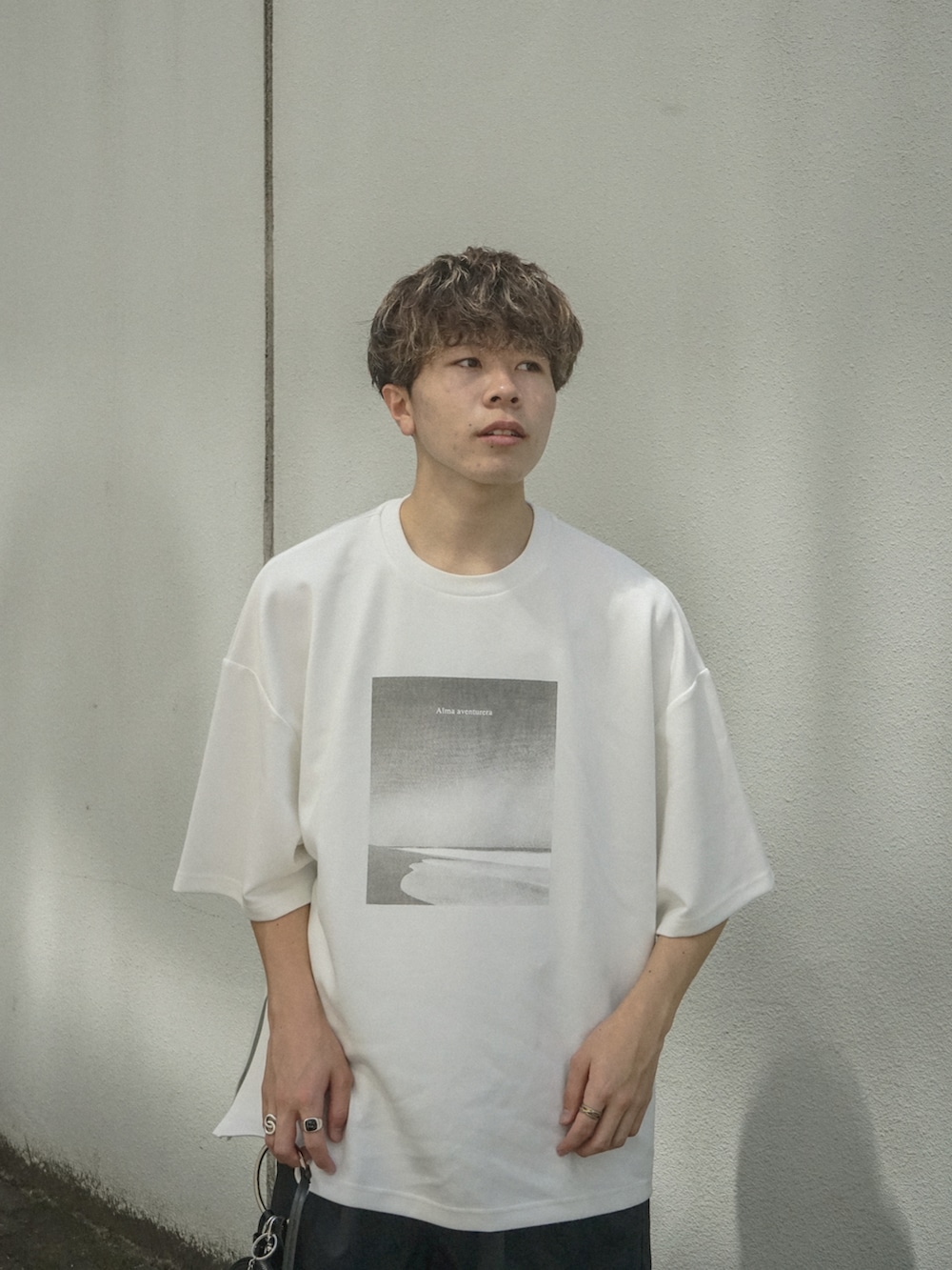 ホワイト系のTシャツ/カットソー、ブラック系のその他パンツ、ブラック系のショルダーバッグを着用したメンズの夏コーディネートの3枚目の写真