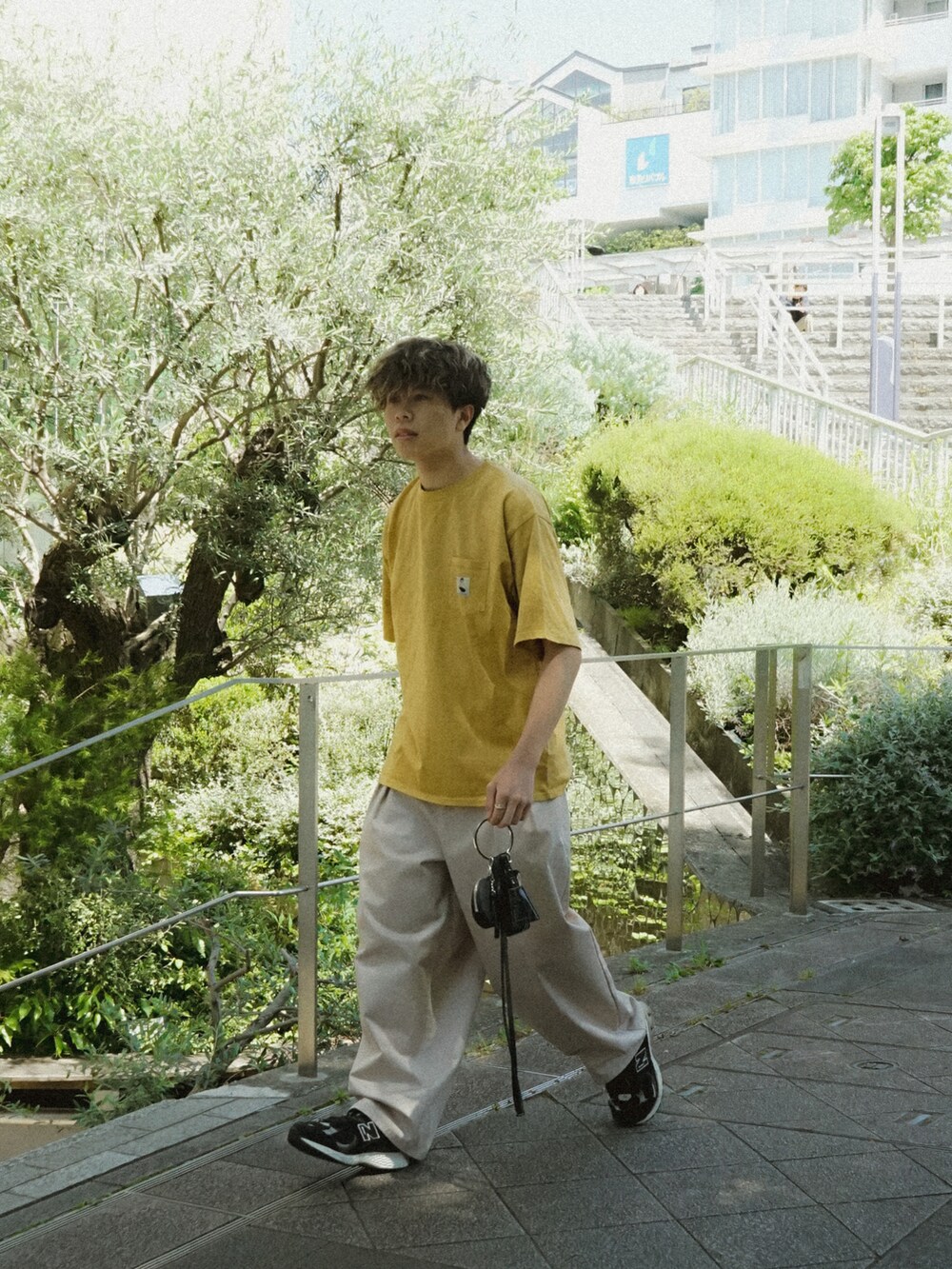 イエロー系のTシャツ/カットソー、ベージュ系のその他パンツ、ブラック系のショルダーバッグを着用したメンズの春コーディネートの4枚目の写真