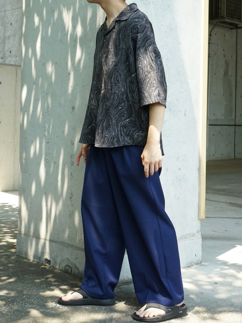 ブラック系のシャツ/ブラウス、ブルー系のスラックス、ブラック系のサンダルを着用したメンズの夏コーディネートの4枚目の写真