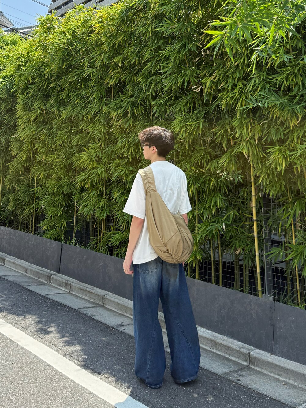 ベージュ系のその他シューズ、ブルー系のデニムパンツ、ベージュ系のショルダーバッグを着用したメンズの夏コーディネートの3枚目の写真