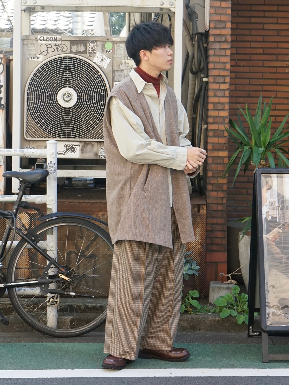 ブラウン系のベスト、ベージュ系のシャツ/ブラウス、レッド系のTシャツ/カットソーを着用したメンズの秋コーディネートの2枚目の写真