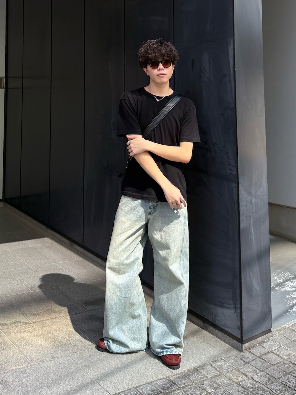 ブラック系のTシャツ/カットソー、ブルー系のデニムパンツ、ブラック系のショルダーバッグを着用したメンズの秋コーディネートの2枚目の写真