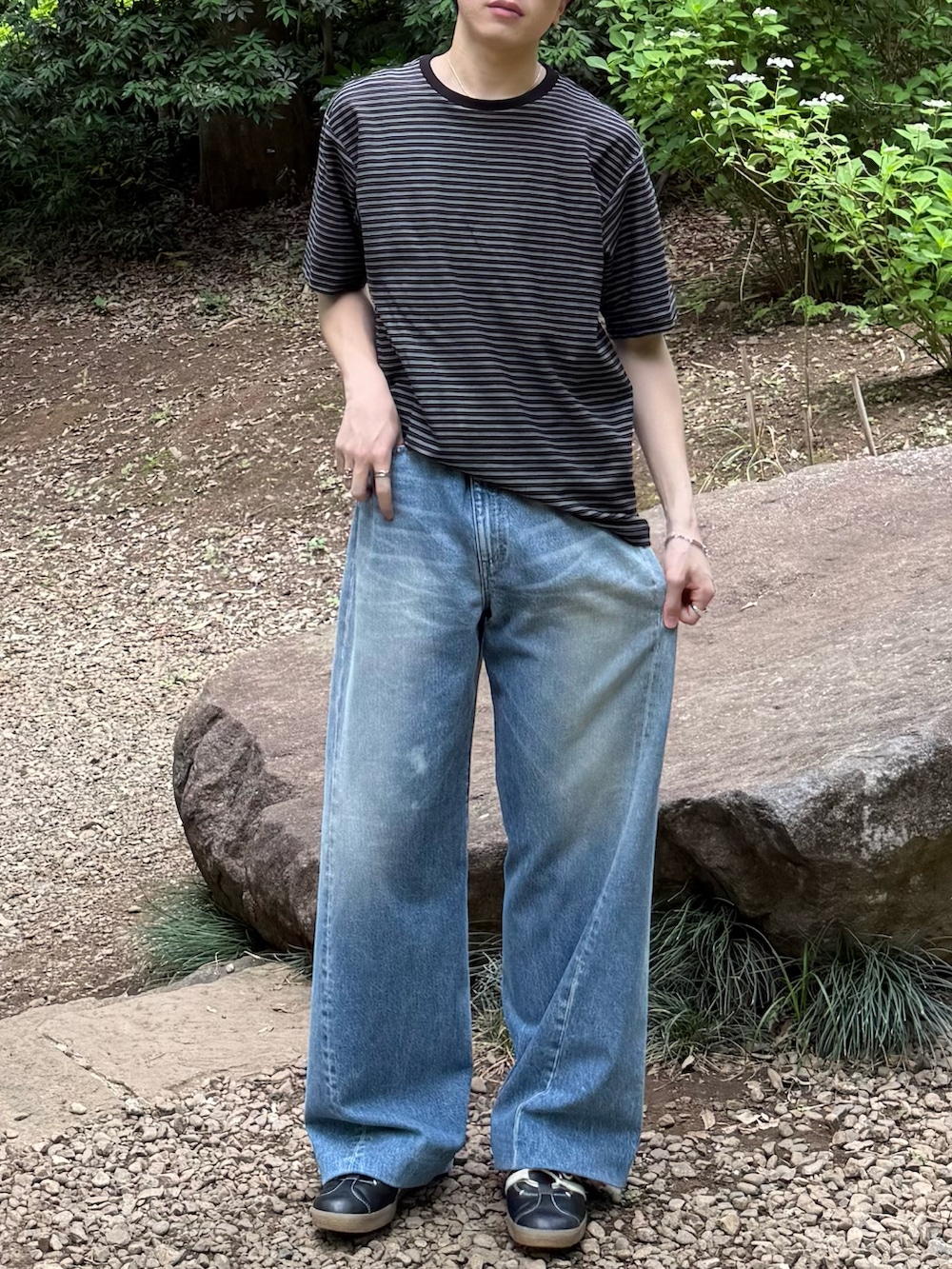 ブラック系のTシャツ/カットソー、ブルー系のデニムパンツ、ブラック系のスニーカーを着用したメンズの春コーディネートの5枚目の写真