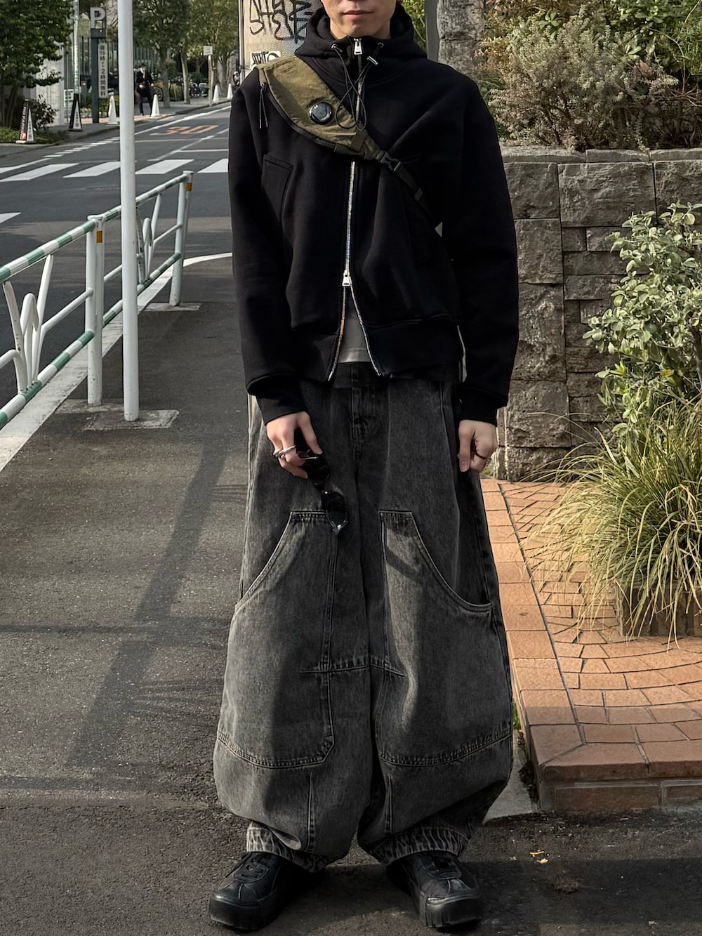 ブラック系のパーカー、ホワイト系のTシャツ/カットソー、グリーン系のバックパック/リュックを着用したメンズの春コーディネートの3枚目の写真