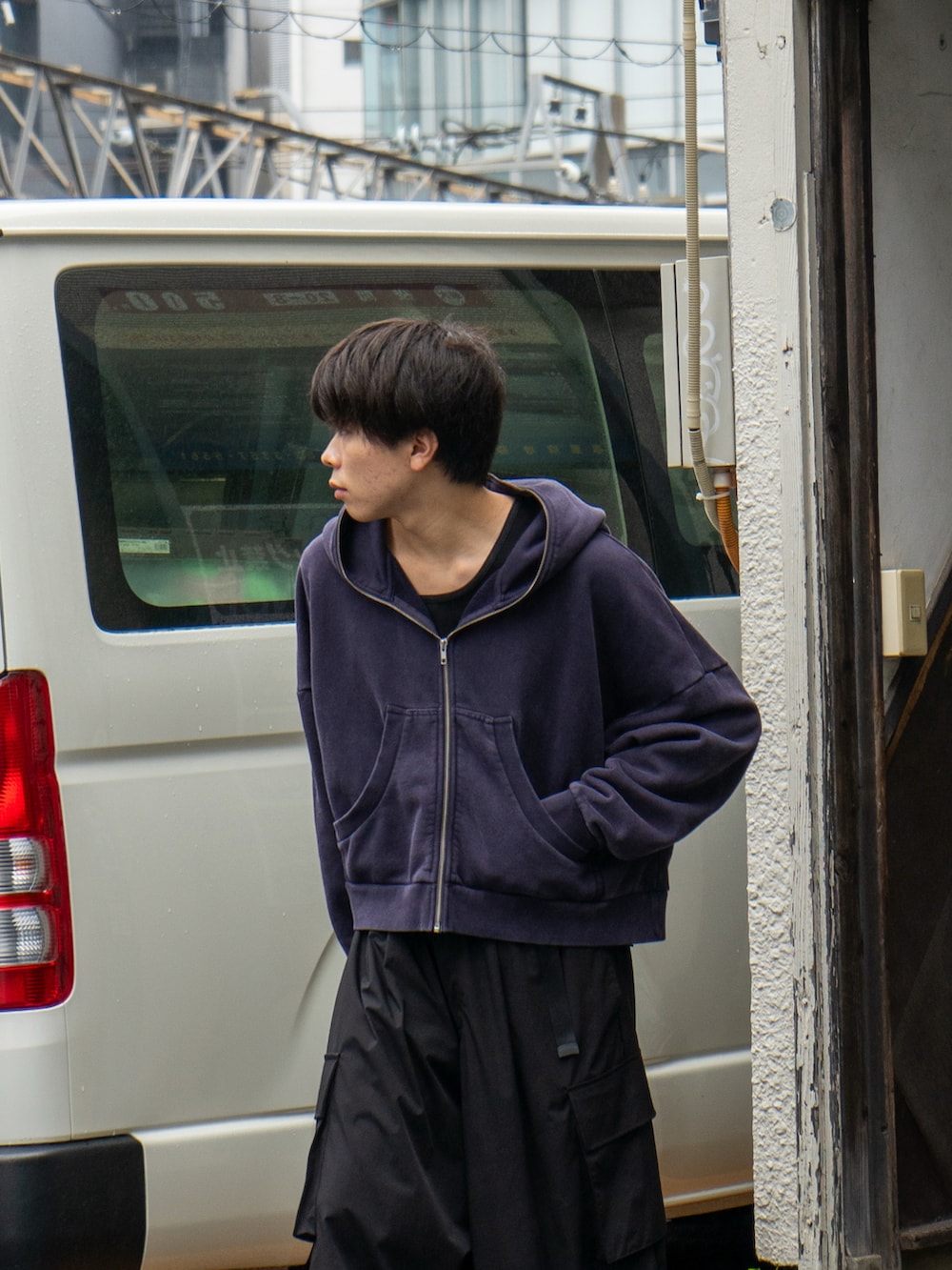 ブラック系のパーカー、ブラック系のカーゴパンツ、ブラウン系のサンダルを着用したメンズの秋コーディネートの3枚目の写真