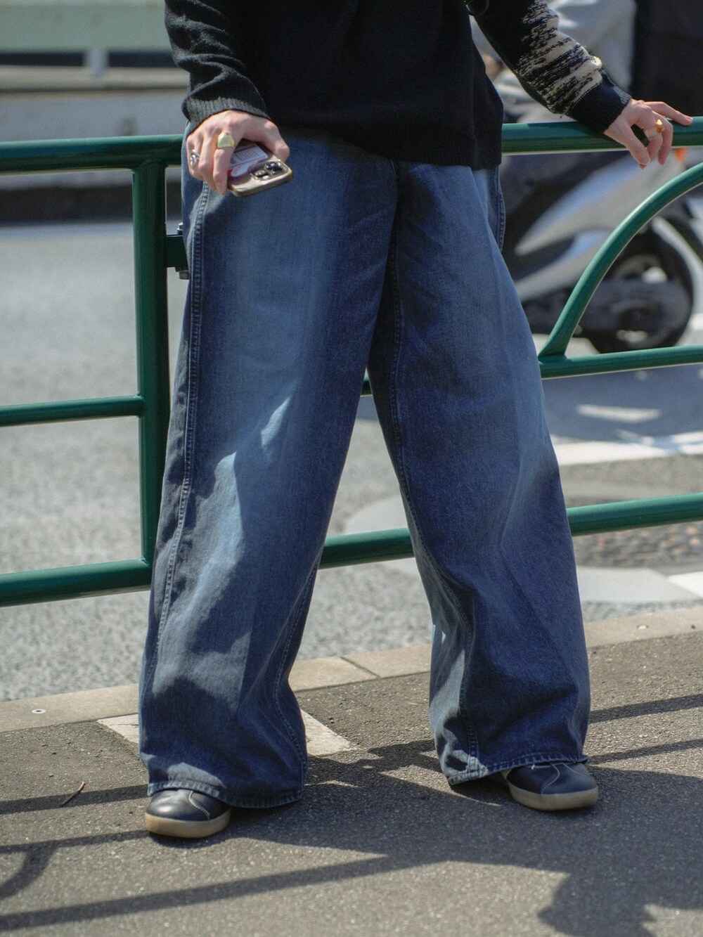 ブラック系のニット/セーター、ブラック系のショルダーバッグ、ブルー系のデニムパンツを着用したメンズの春コーディネートの4枚目の写真