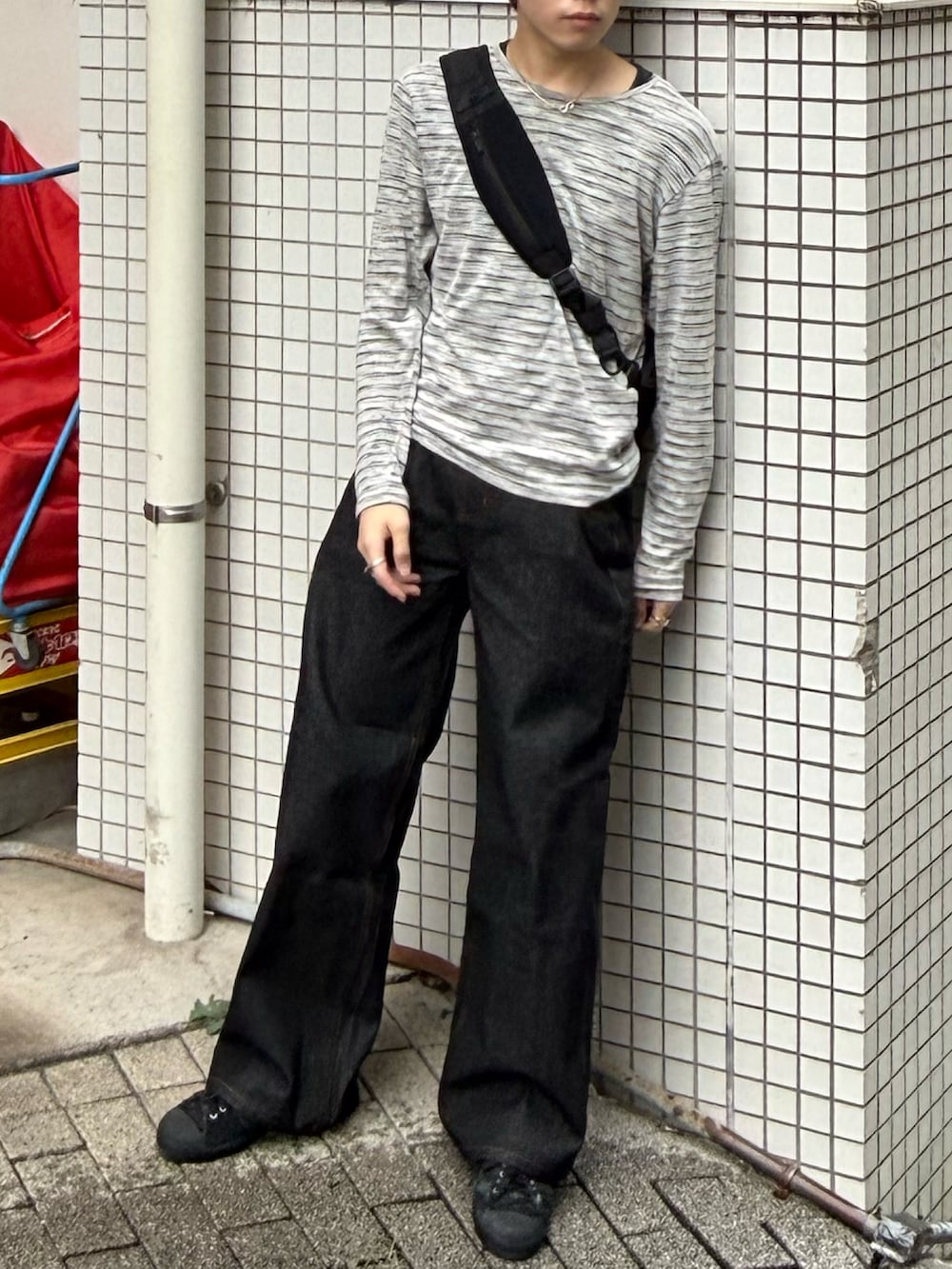 グレー系のTシャツ/カットソー、ブラック系のデニムパンツ、ブラック系のショルダーバッグを着用したメンズの秋コーディネートの2枚目の写真