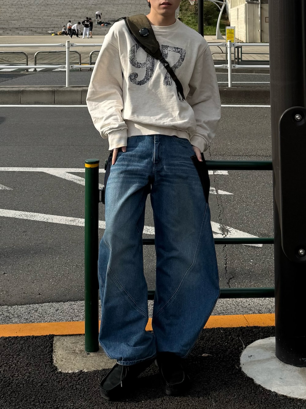 ホワイト系のスウェット、ブルー系のデニムパンツ、グリーン系のバックパック/リュックを着用したメンズの春コーディネートの3枚目の写真