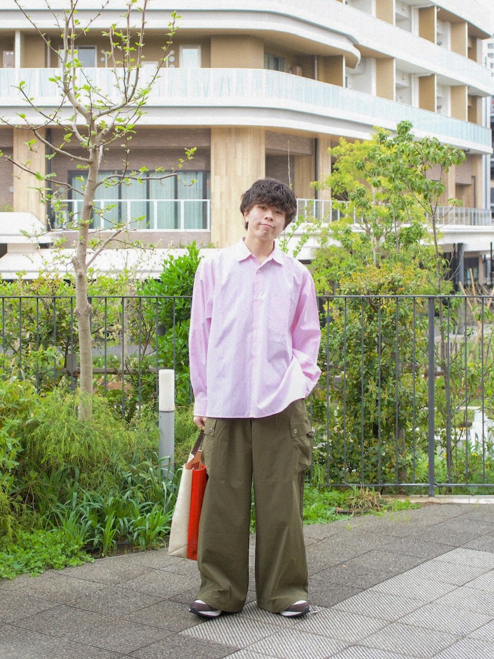 ピンク系のシャツ/ブラウス、グリーン系のカーゴパンツ、ホワイト系のトートバッグを着用したメンズの春コーディネートの3枚目の写真