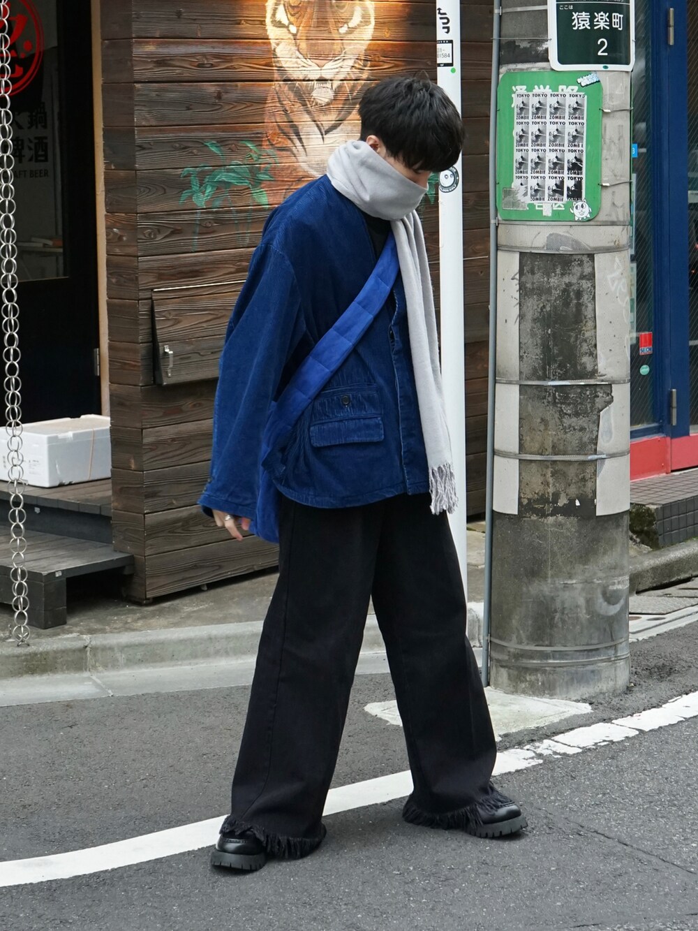 ブルー系のテーラードジャケット、ブラック系のデニムパンツ、ブルー系のショルダーバッグを着用したメンズの冬コーディネートの2枚目の写真