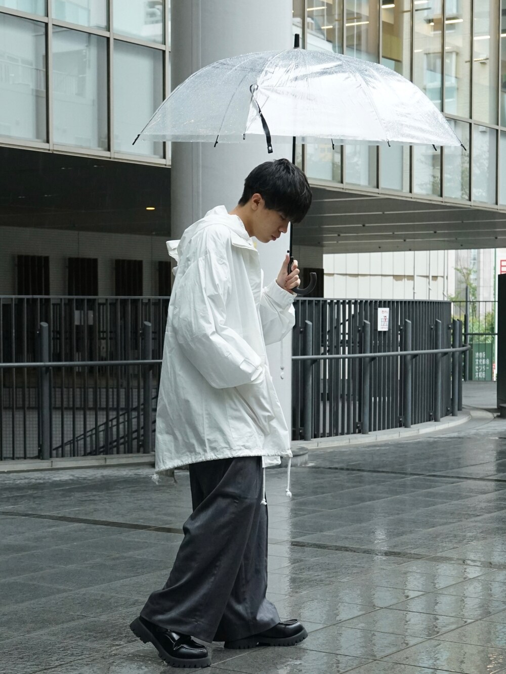 ホワイト系のマウンテンパーカー、グレー系のスウェット、グレー系のスラックスを着用したメンズの秋コーディネートの4枚目の写真