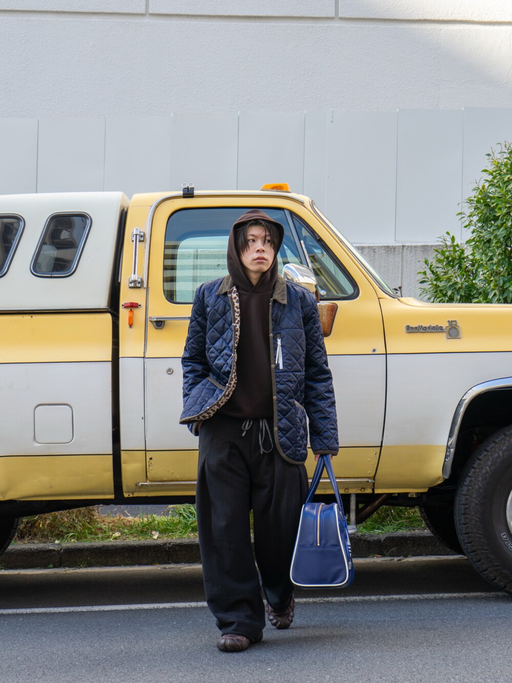 ブラック系のスウェットパンツ、ブルー系のボストンバッグ、ブラウン系のスニーカーを着用したメンズの冬コーディネートの3枚目の写真