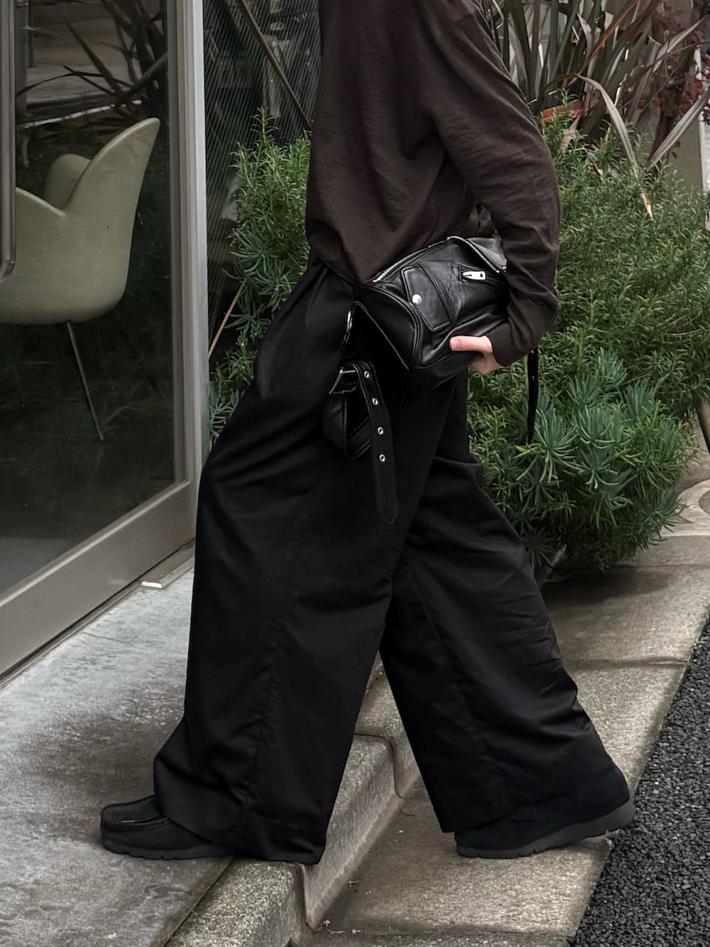 ブラック系のその他パンツ、ブラック系のショルダーバッグ、ブラック系のモカシン/デッキシューズを着用したメンズの春コーディネートの4枚目の写真