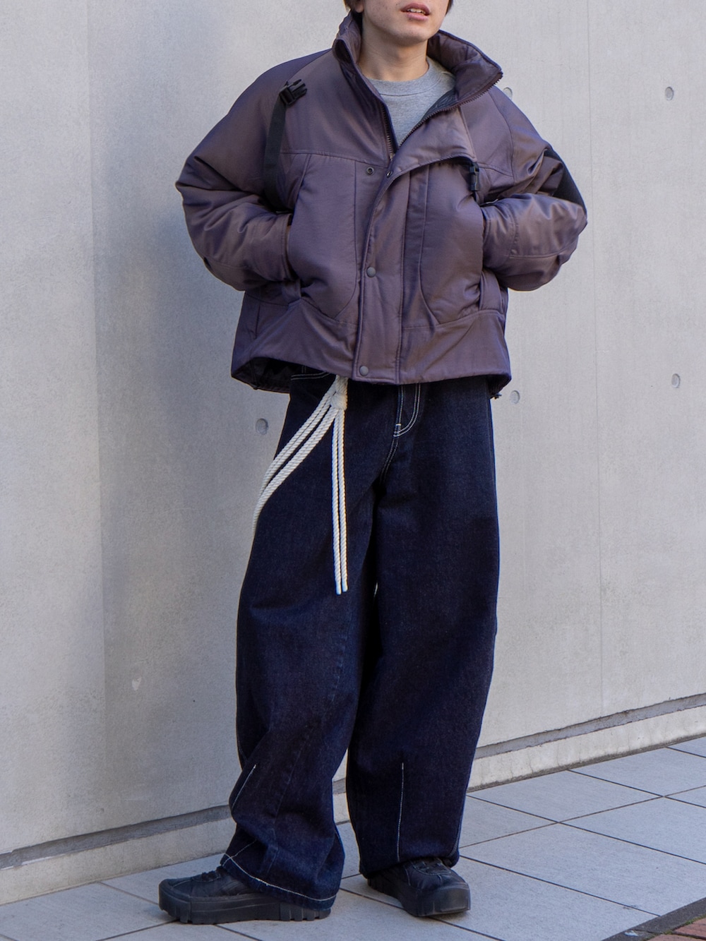 パープル系のブルゾン、グレー系のスウェット、ブラック系のスニーカーを着用したメンズの冬コーディネートの5枚目の写真