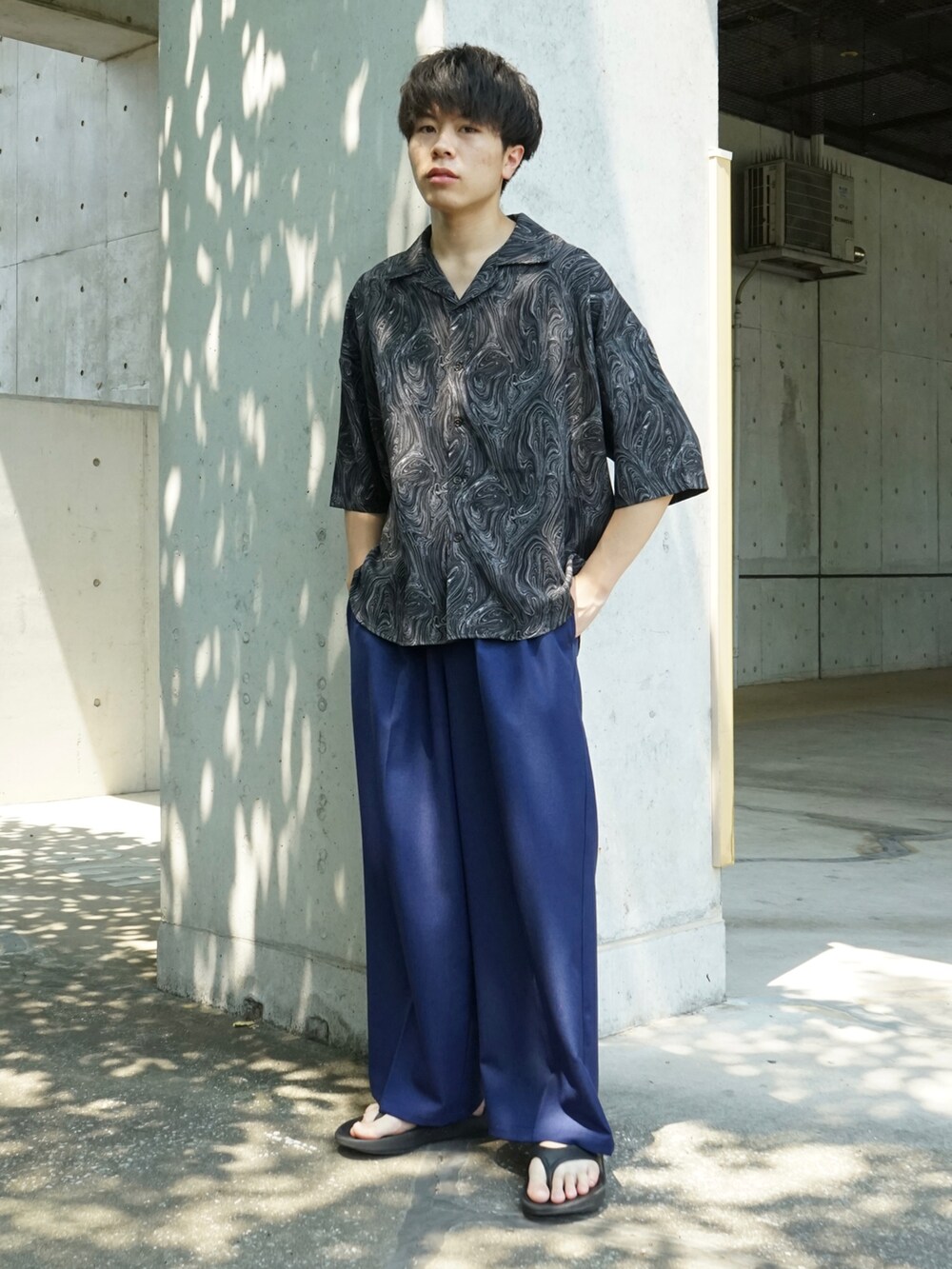 ブラック系のシャツ/ブラウス、ブルー系のスラックス、ブラック系のサンダルを着用したメンズの夏コーディネートの3枚目の写真